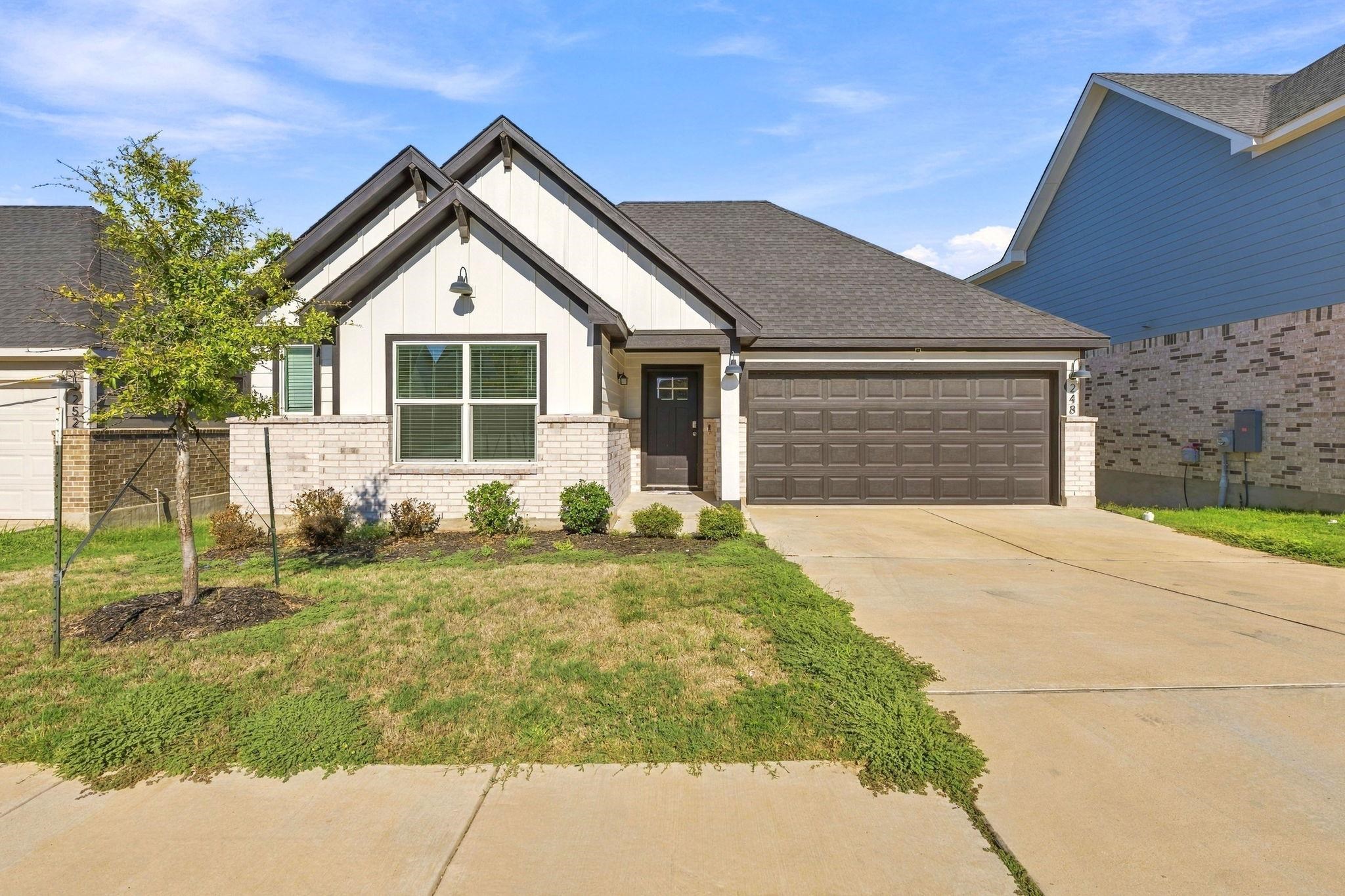 Modern craftsman elevation with a mix of brick and board-and-batten siding greets visitors.