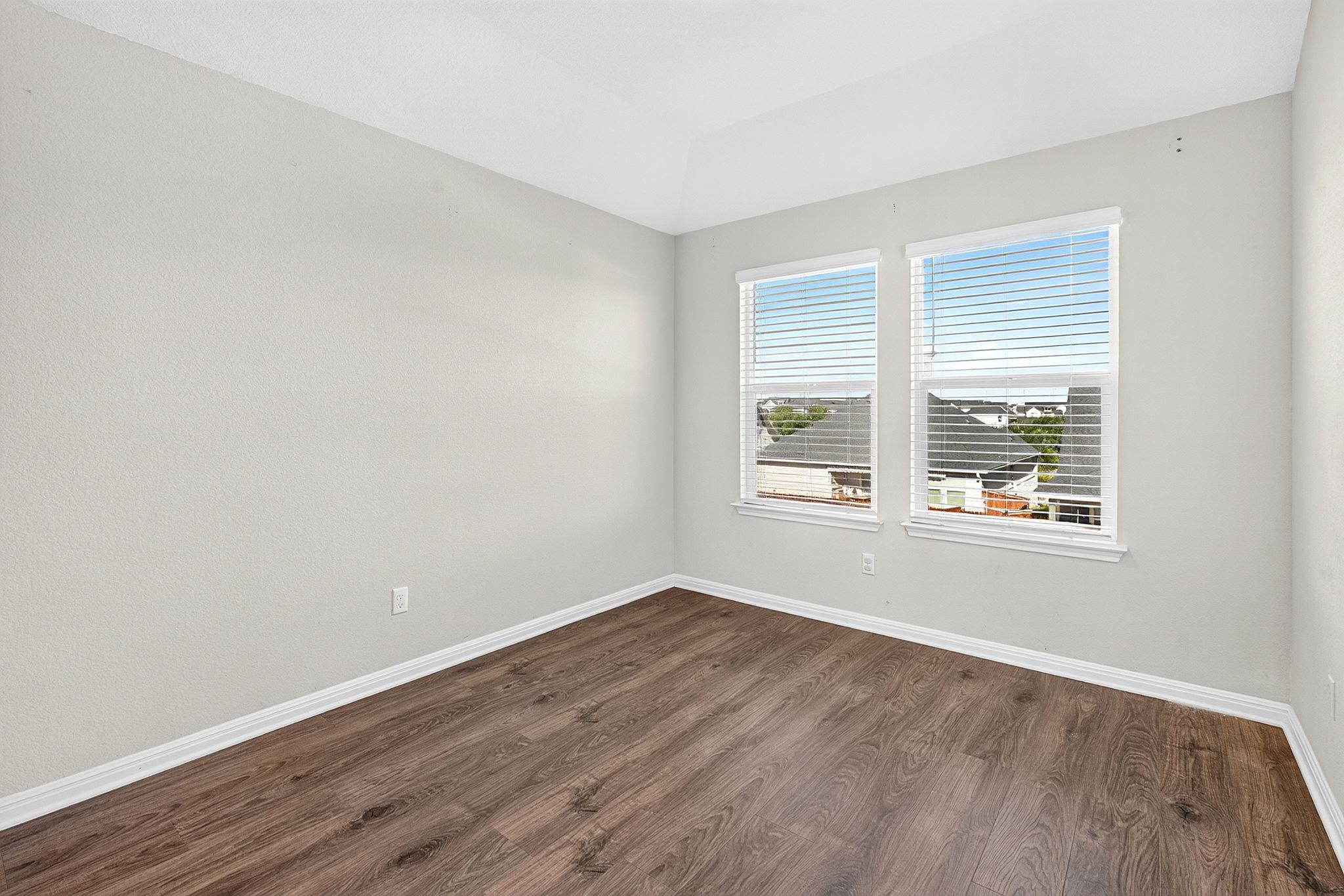 Rich wood-inspired flooring and an elegant tray ceiling define this versatile room.