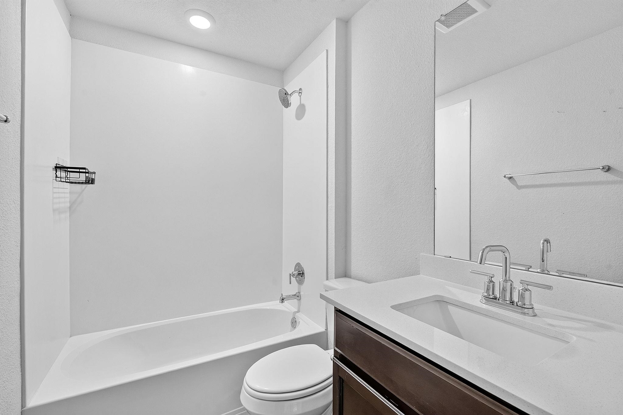 A clean vanity and integrated tub shower design maximize the functionality of this layout.