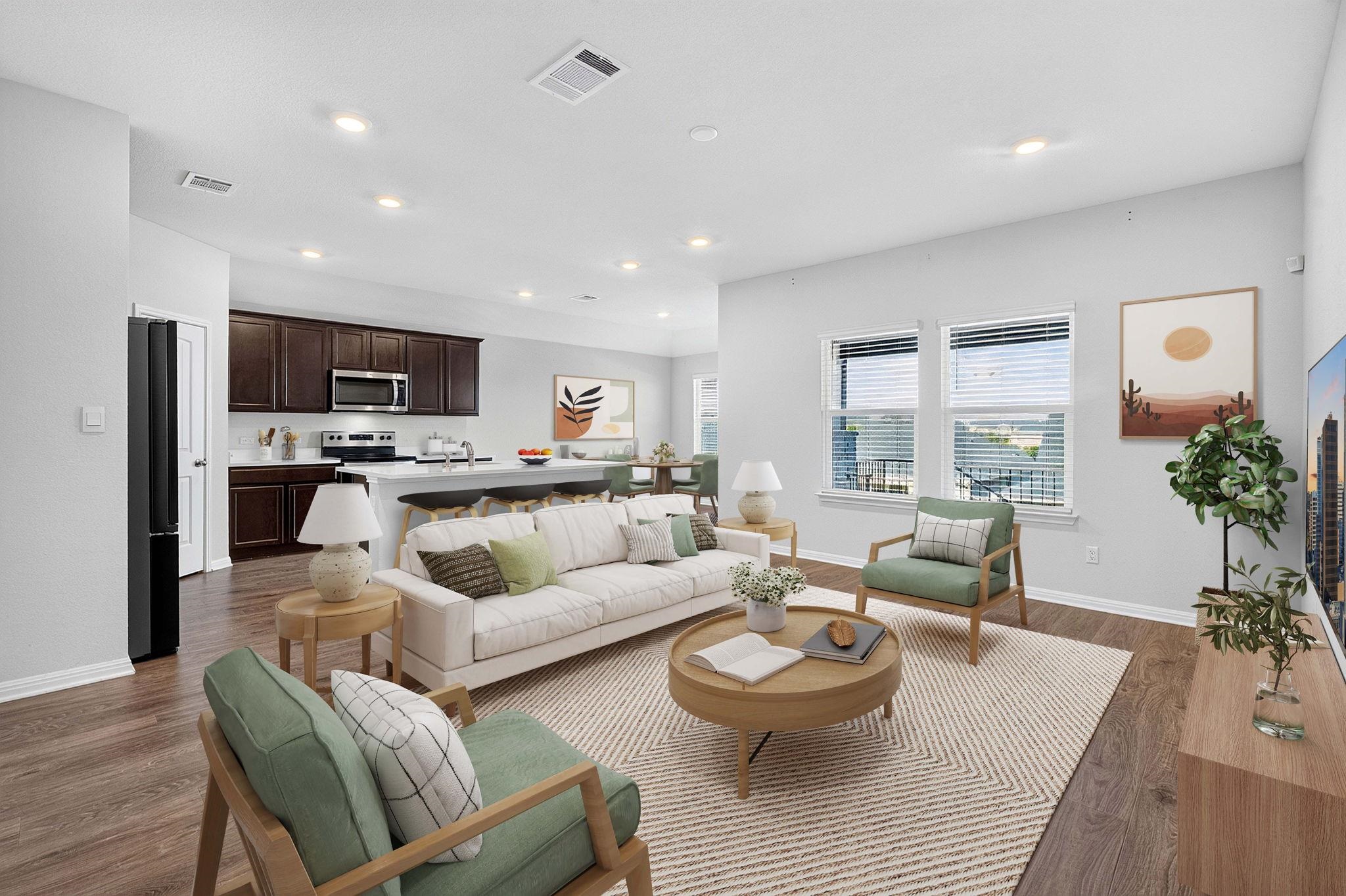 Recessed lighting illuminates this seamless open floorplan connecting the living area and kitchen.