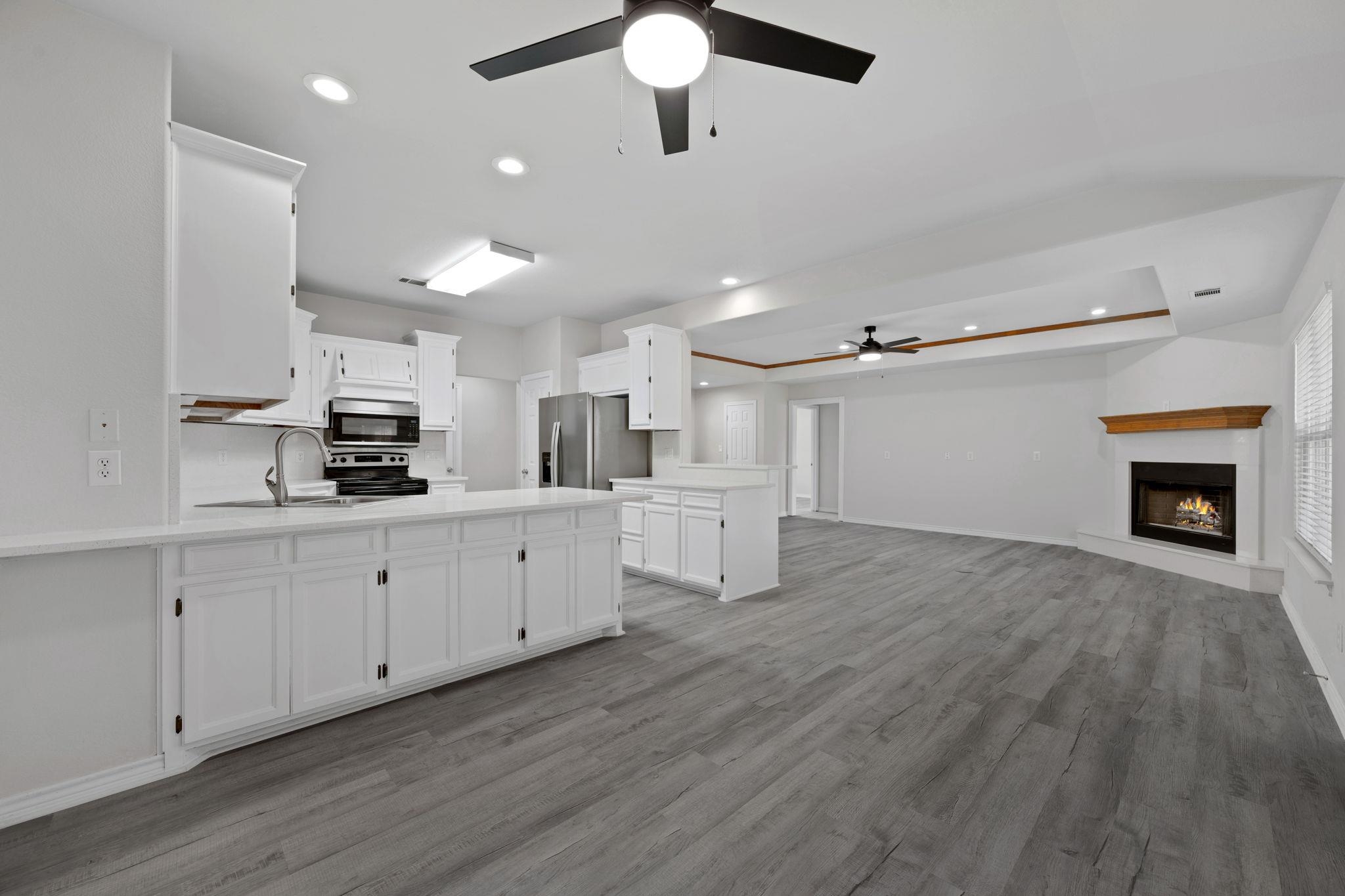 Kitchen featuring recessed lighting, a peninsula, white cabinets, ceiling fan, and open floor plan