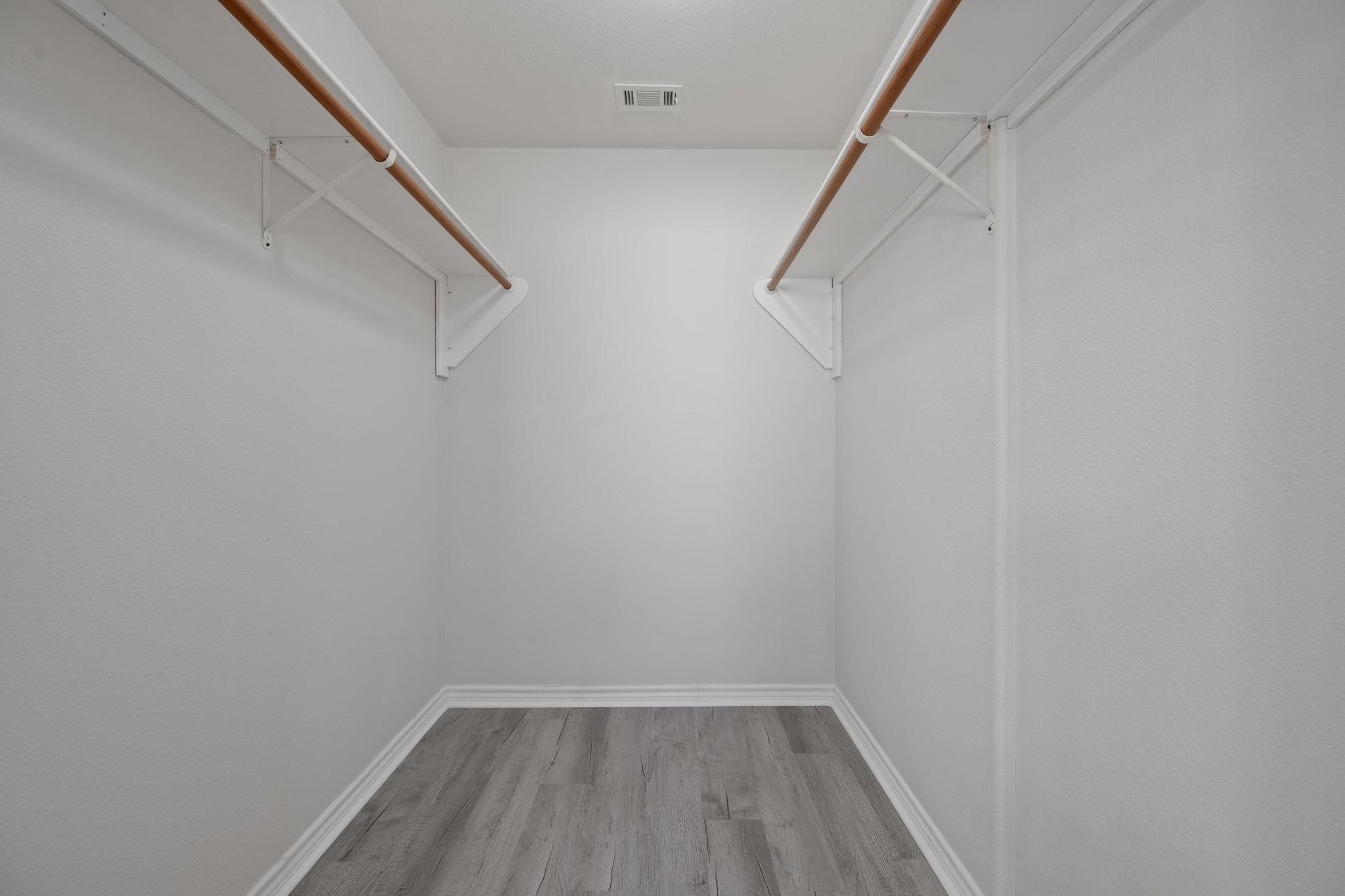 Spacious walk-in closet featuring light wood-type flooring