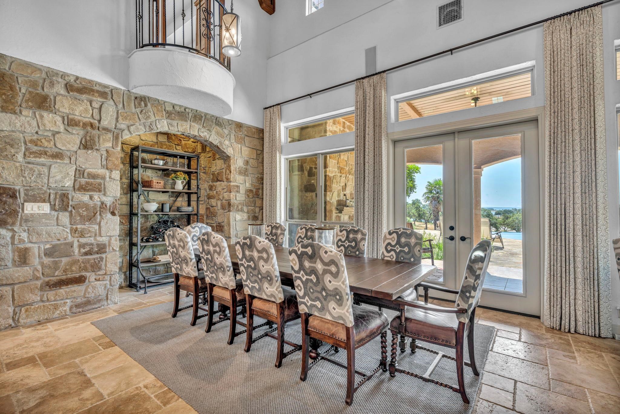 Dining area with stone tile floors, a high ceiling, and french doors