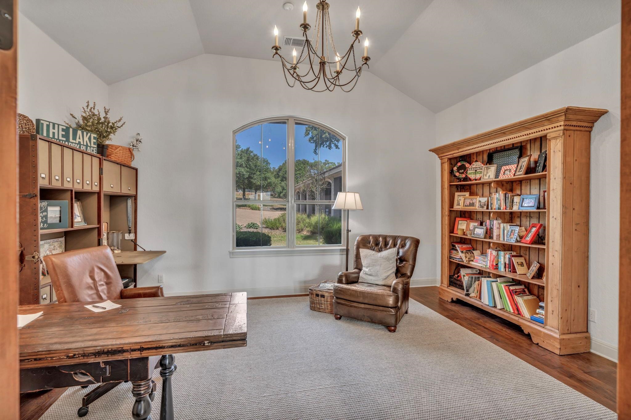 One of two formal home office/study with vaulted ceiling and chandelier