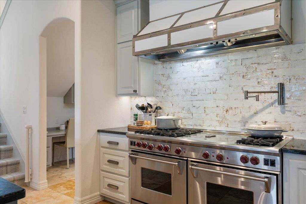 Double Wolfe ovens, 6 burner gas cooktop, and pot filler.