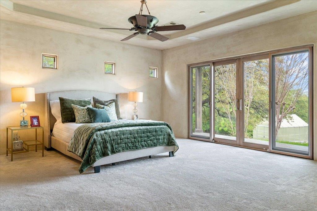 Primary bedroom; new carpet in 2025.  Walls of windows to wake-up to views of the lake!