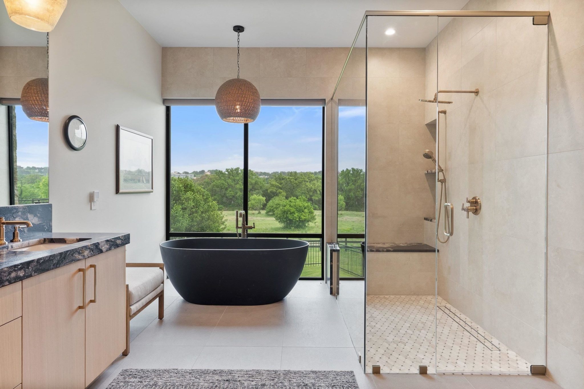 Sculptural freestanding soaking tub, and sleek frameless glass shower showcases meticulous tilework.