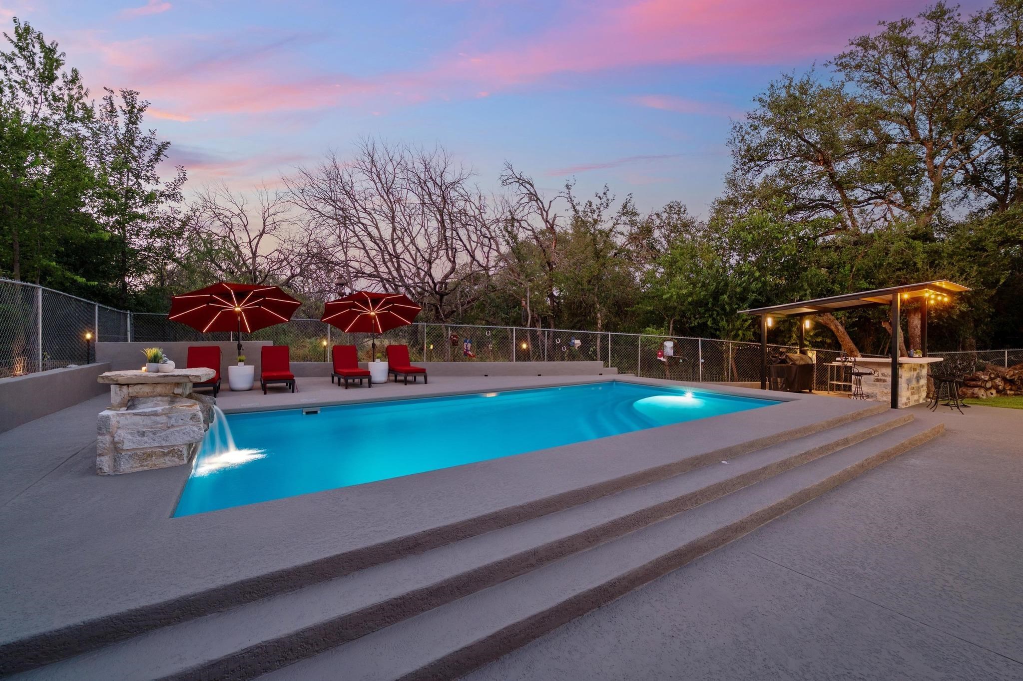 Low-maintenance chilled and heated in-ground pool with tranquil water feature