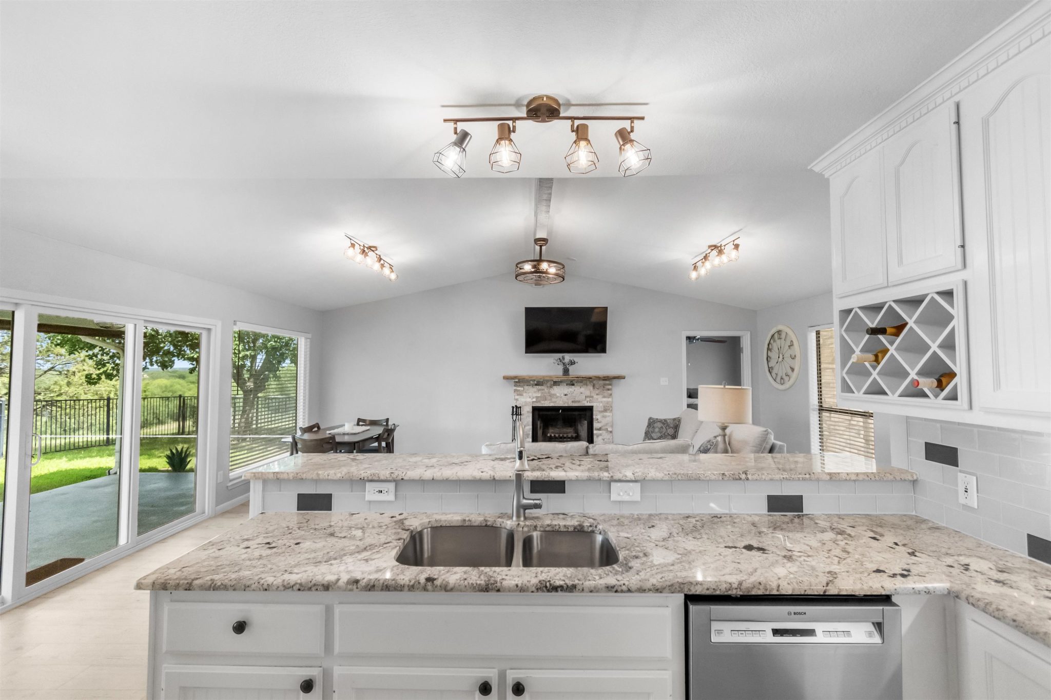 Kitchen open to living and dining room with breakfast bar.