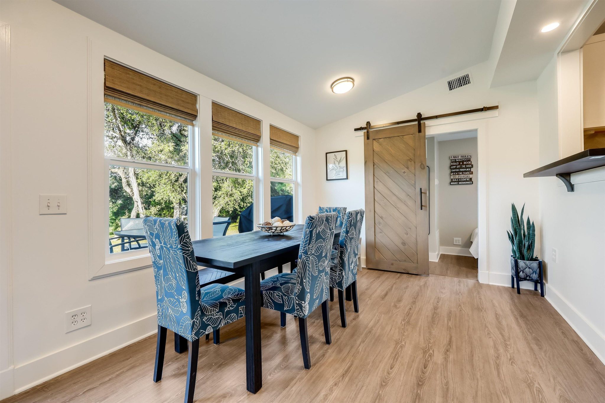 Dining area is open to kitchen and living area. The barn door leads to another bedroom with closet