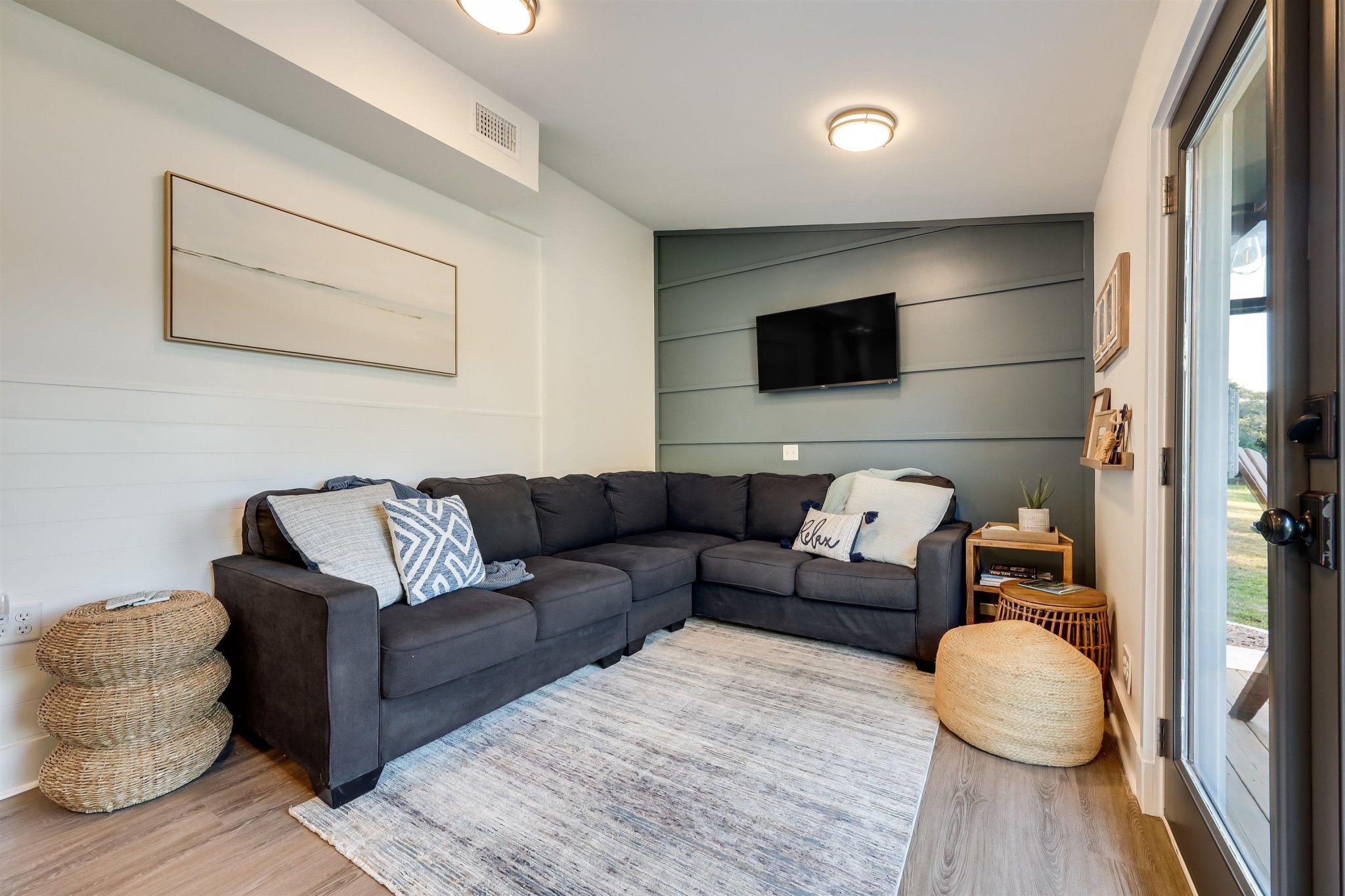 The living room is open to the kitchen and dining area. French doors lead out to the back deck.