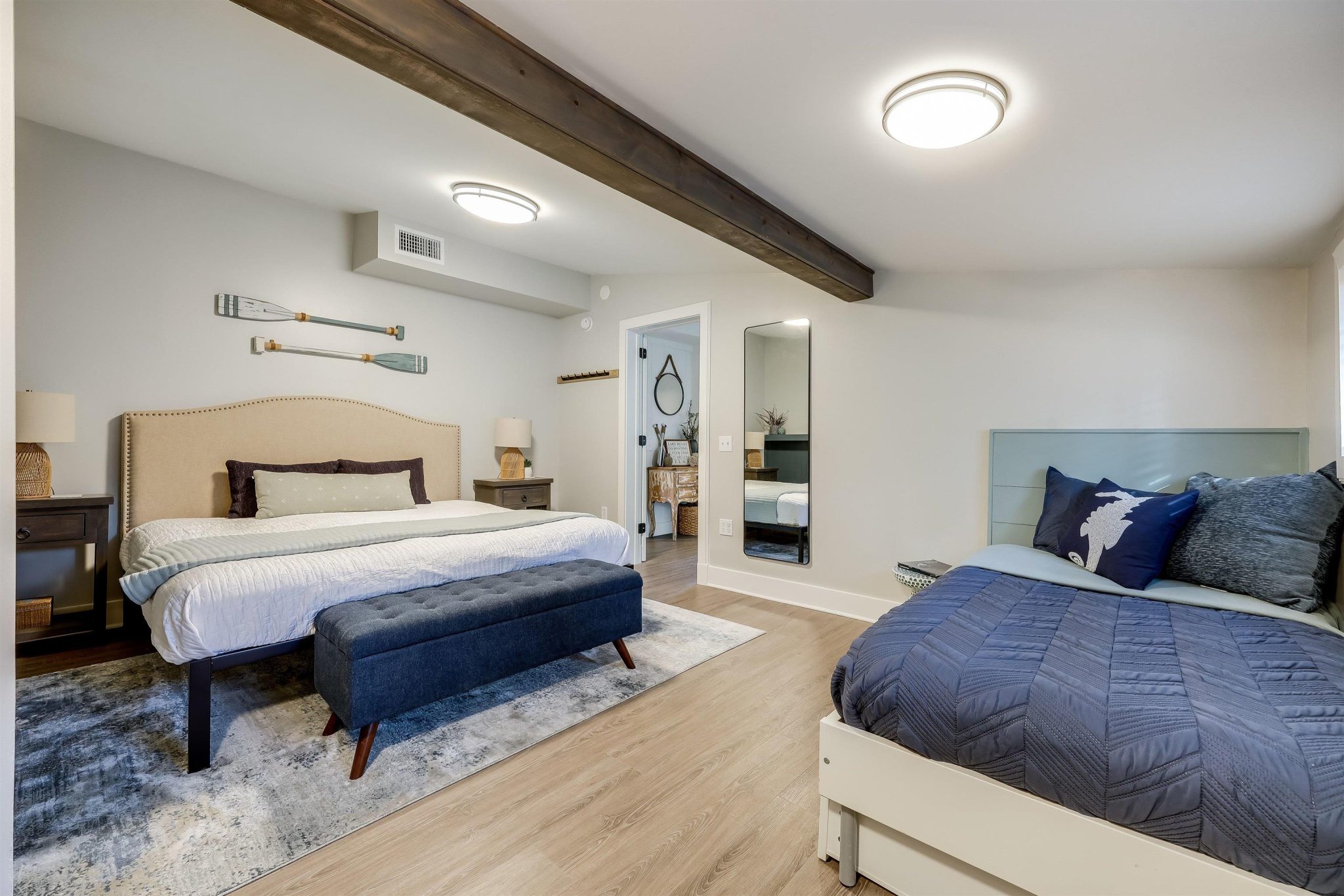 Large primary bedroom with beamed ceiling and board and batten accent wall.