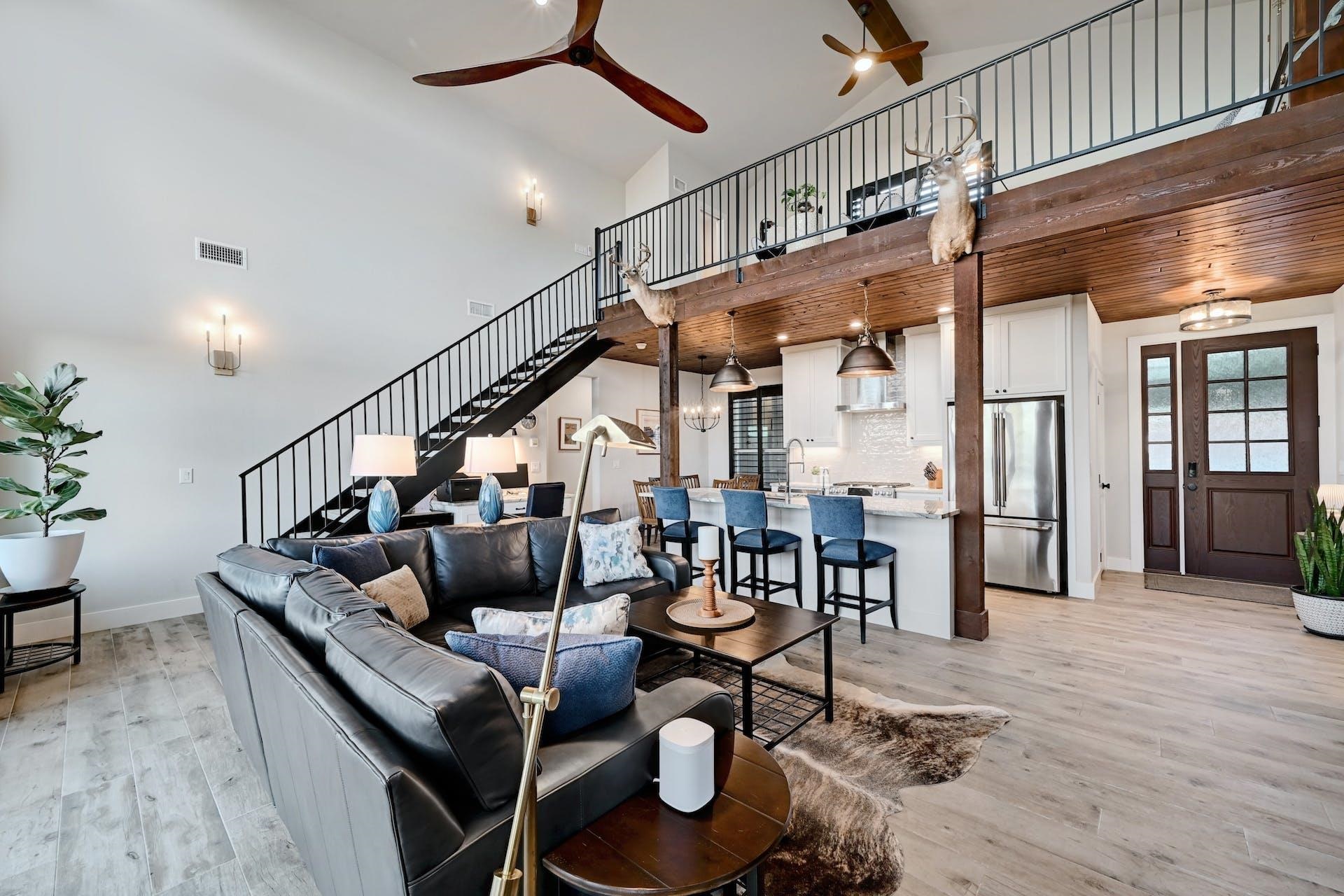 Features include ceiling fans, wall sconces wood-look porcelain tile flooring and an open loft.