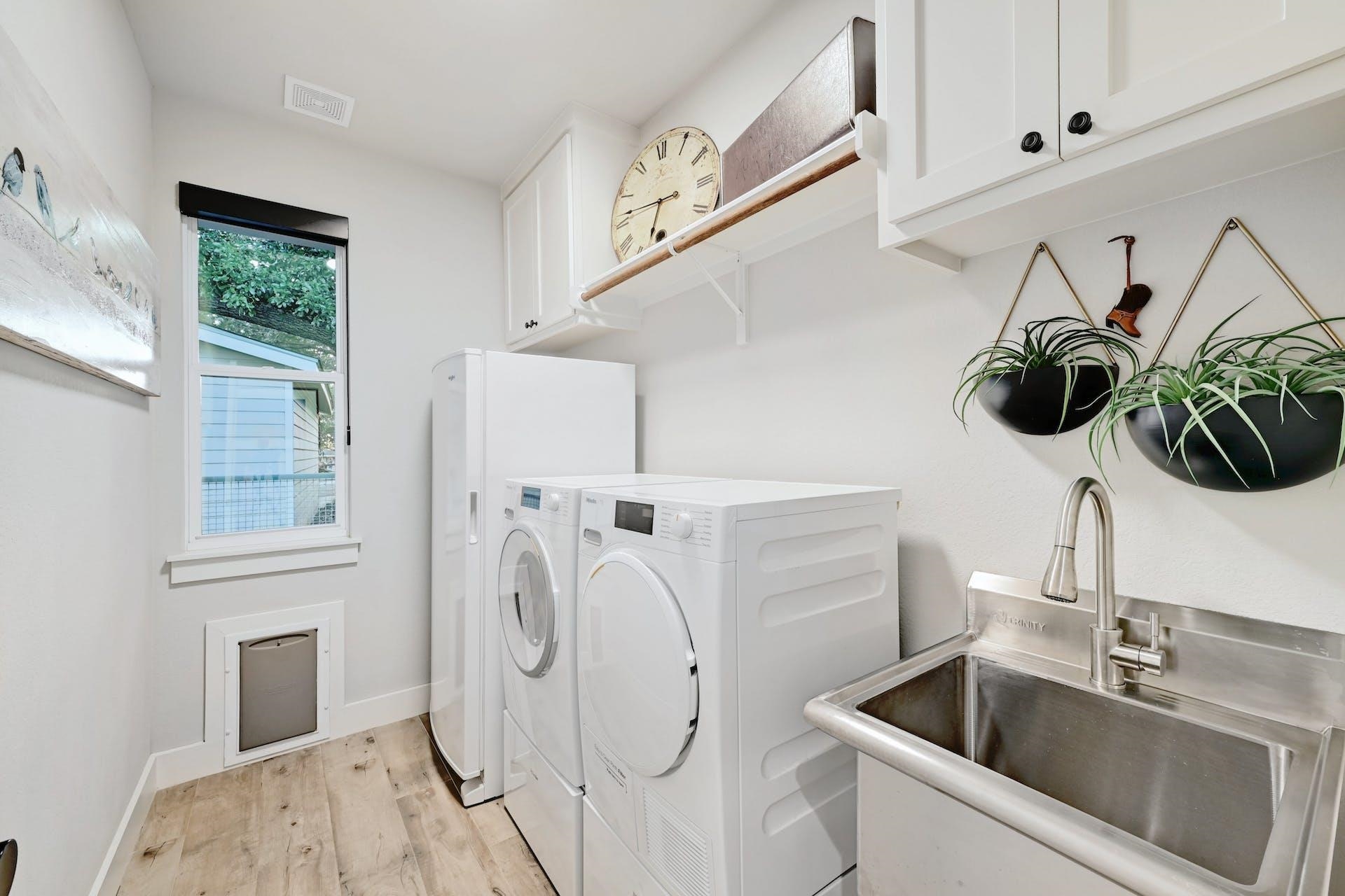 Spacious laundry room with dog door, deep sink and space for a freezer.