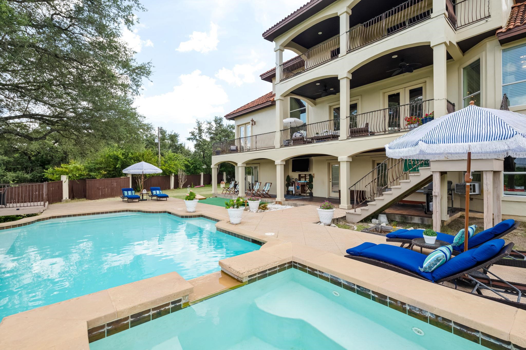 with swimming pool with attached hot tub and waterfall