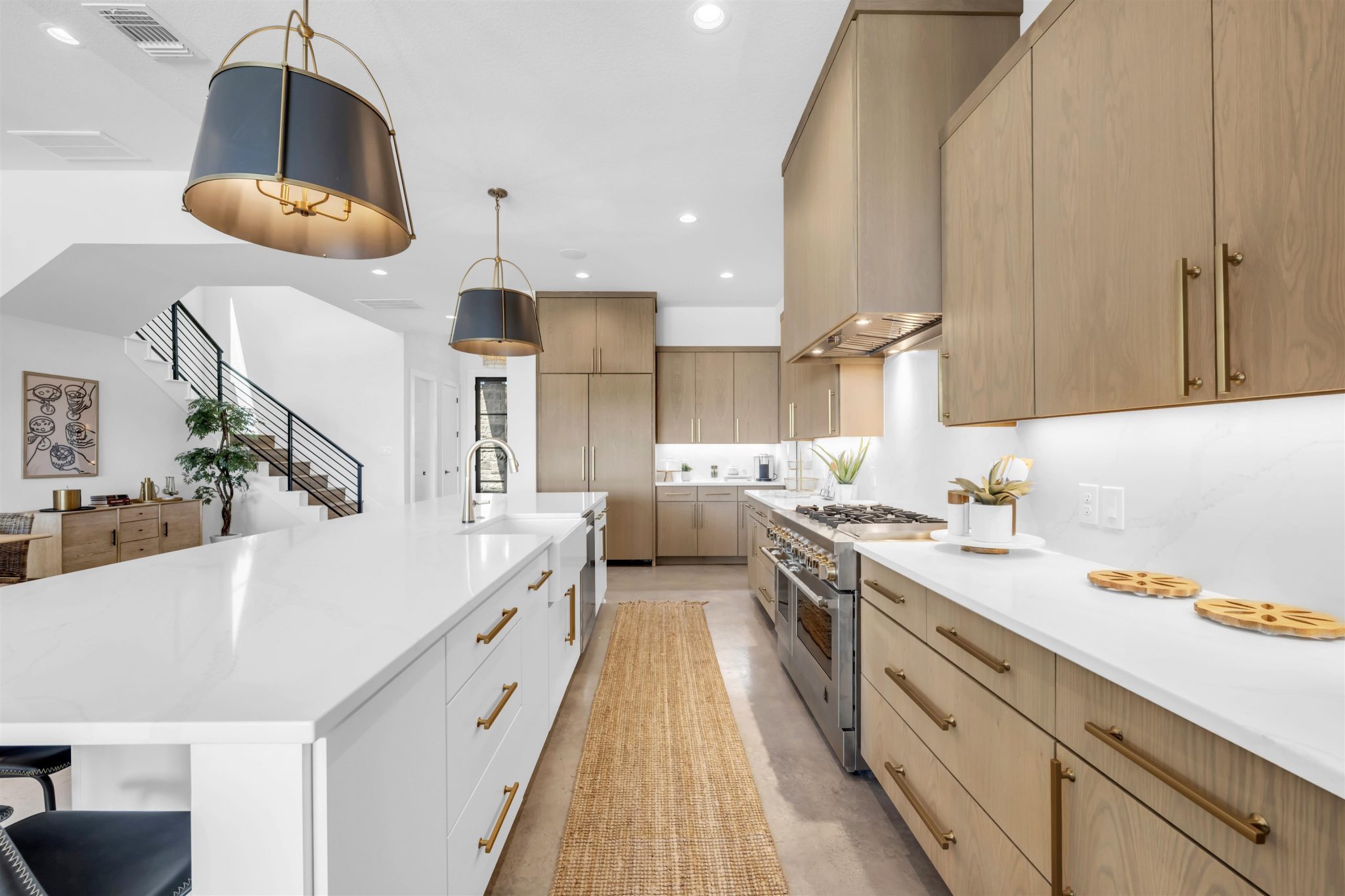 Gleaming quartz countertops pair with custom wood cabinetry in this airy chef kitchen.