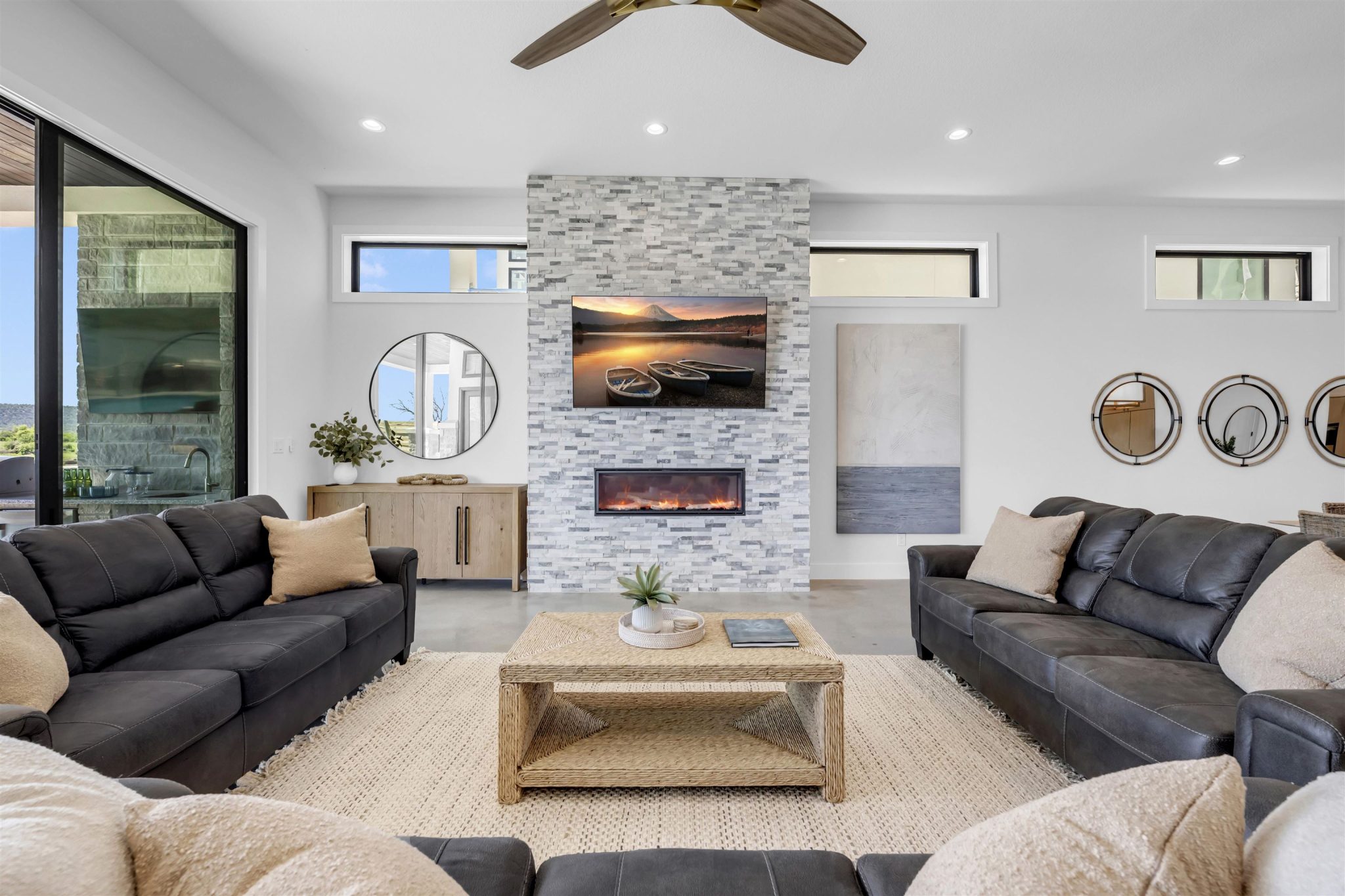 An impressive floor-to-ceiling stone fireplace serves as the centerpiece of this modern living area.