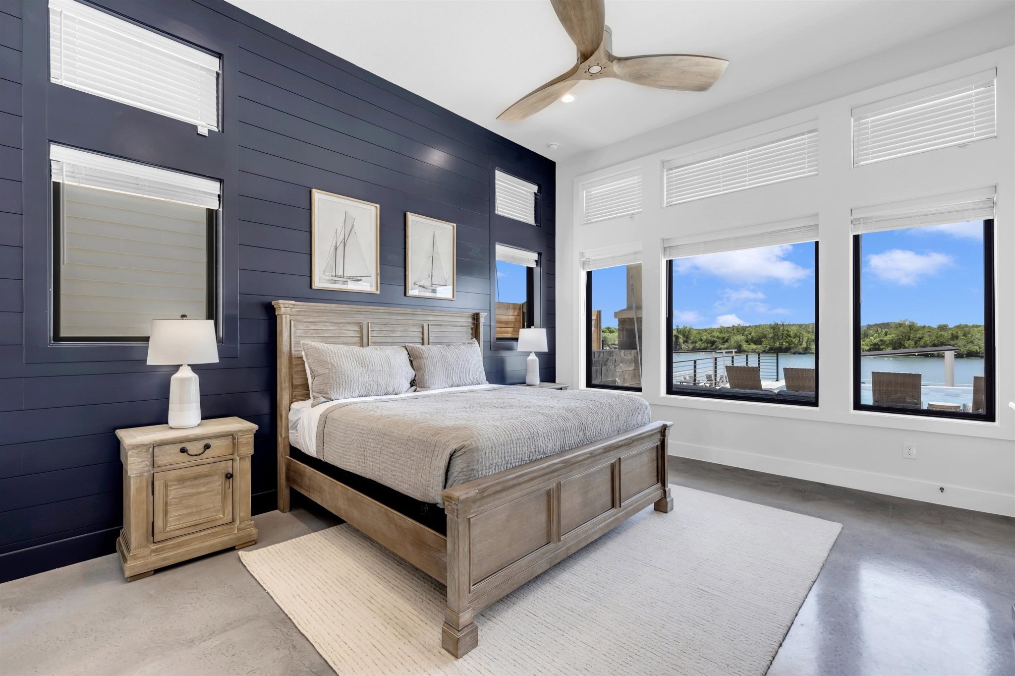 Primary Bedroom on main. High ceilings and generous windows frame tranquil waterfront views.