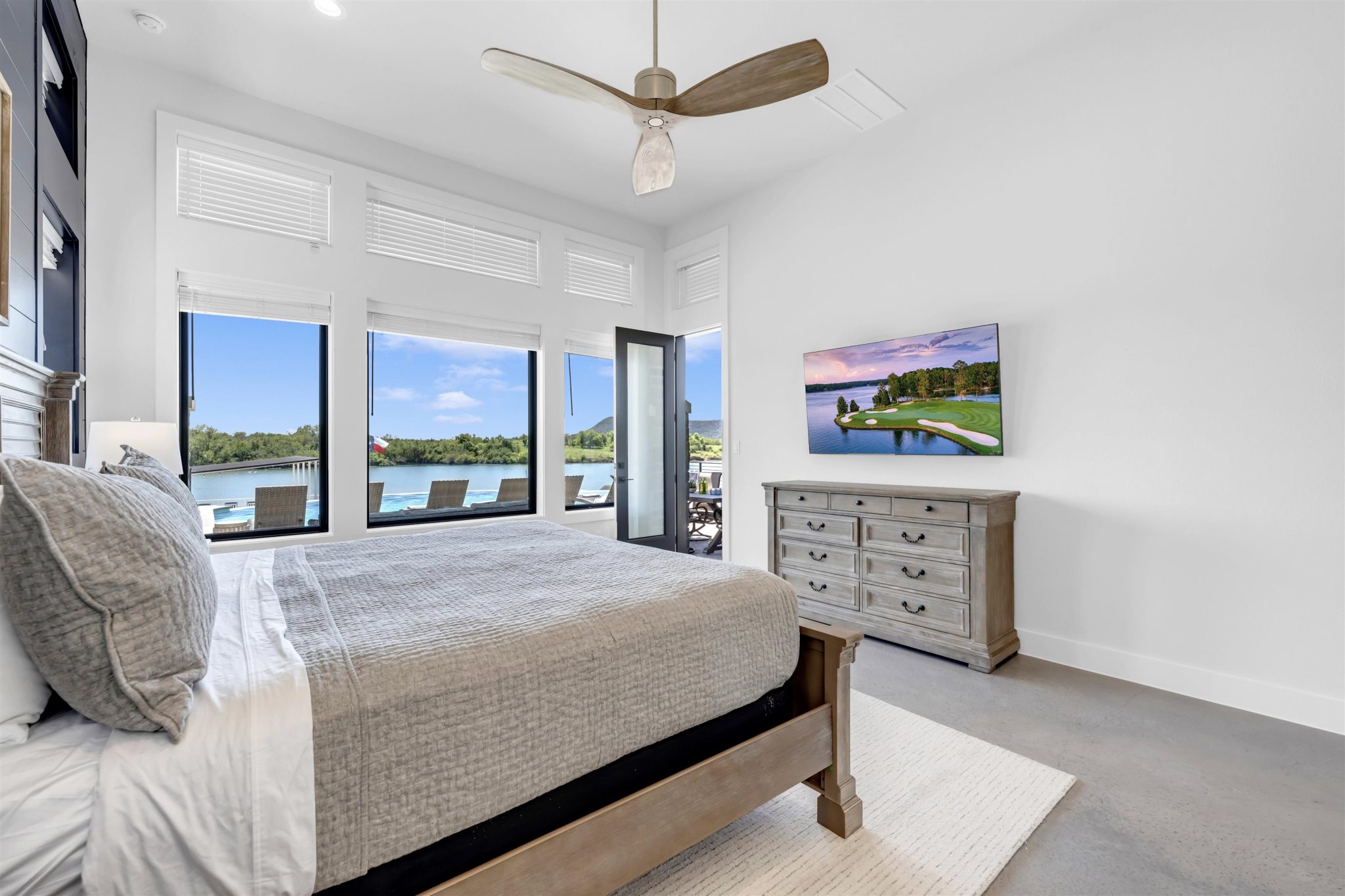 Gleaming concrete floors and massive windows framing scenic water views define this peaceful retreat