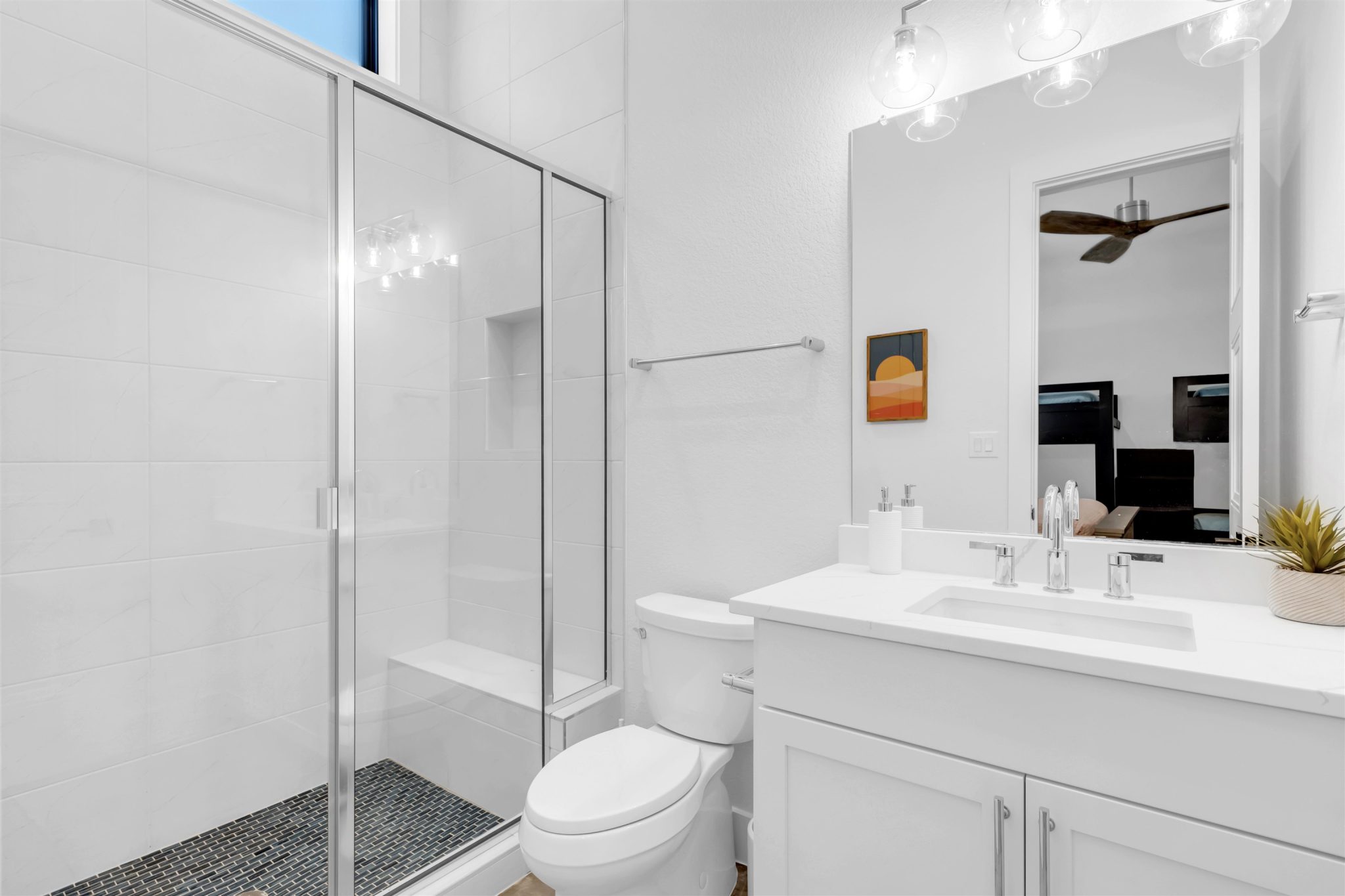 Bathroom two: High ceilings and a glass-enclosed walk-in shower elevate this pristine