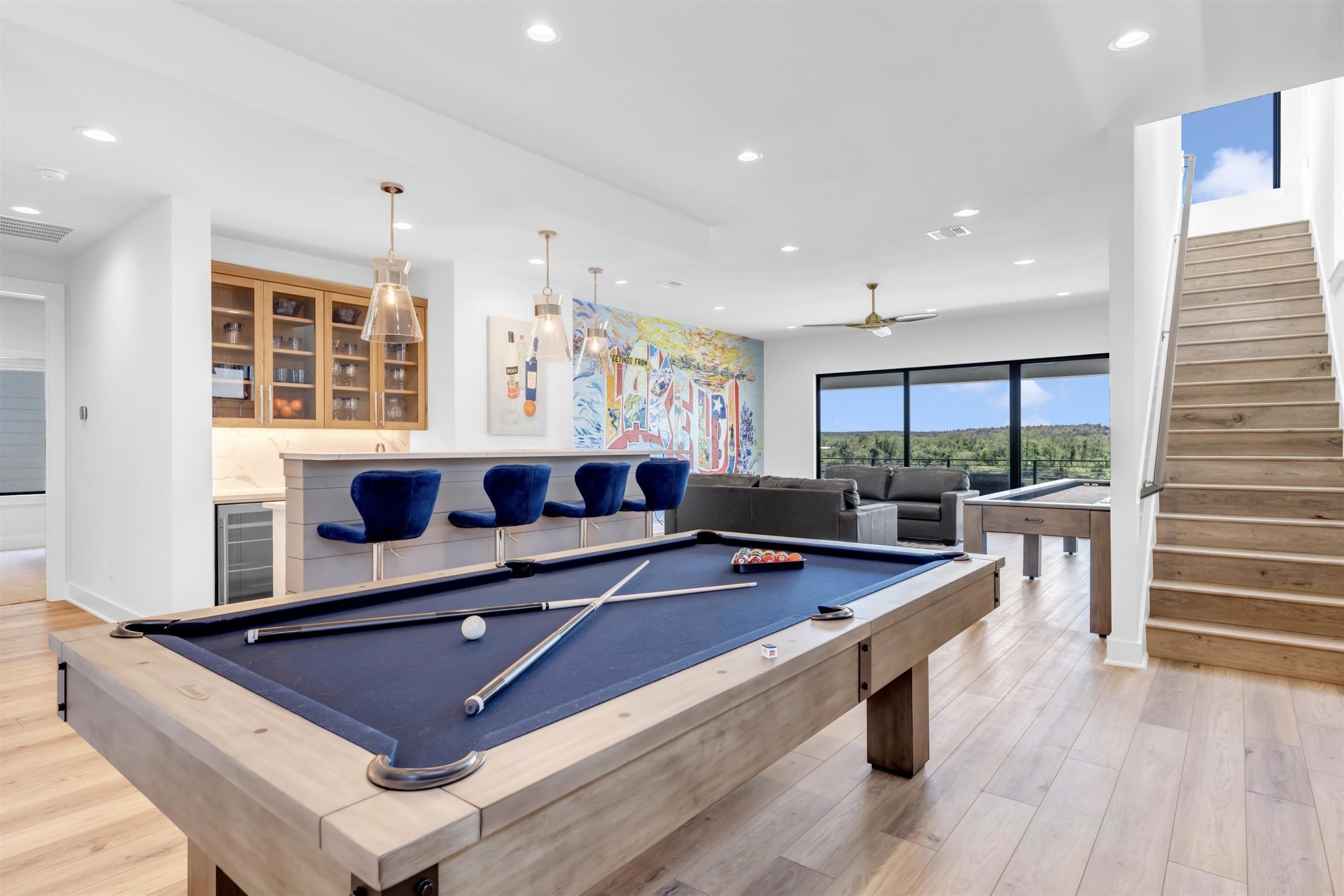 Living room two: Wood floors and floor-to-ceiling glass doors frame tranquil waterfront.