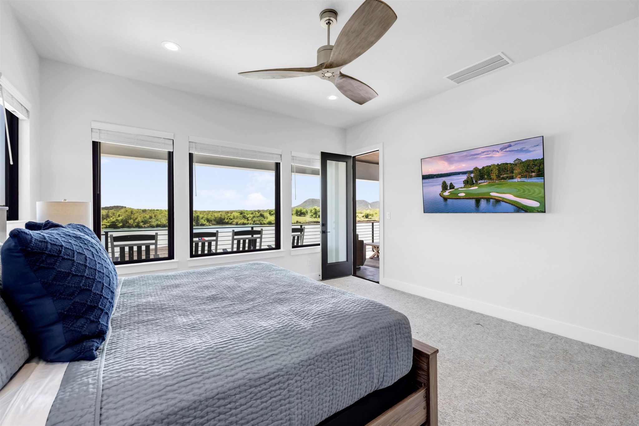Bedroom three: Generous windows frame scenic outdoor vistas in this inviting carpeted bedroom suite.