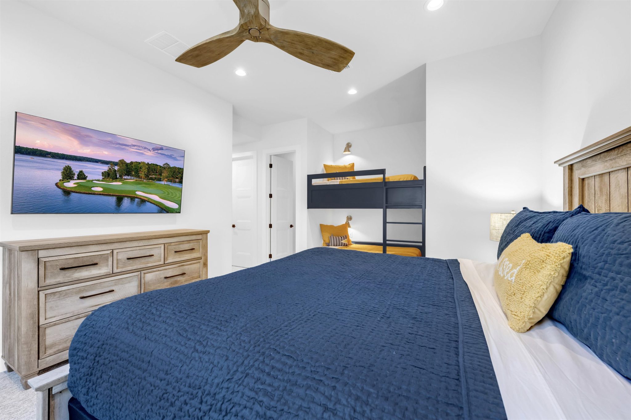 Bedroom six: Recessed lighting illuminates this guest bedroom featuring soft carpet.