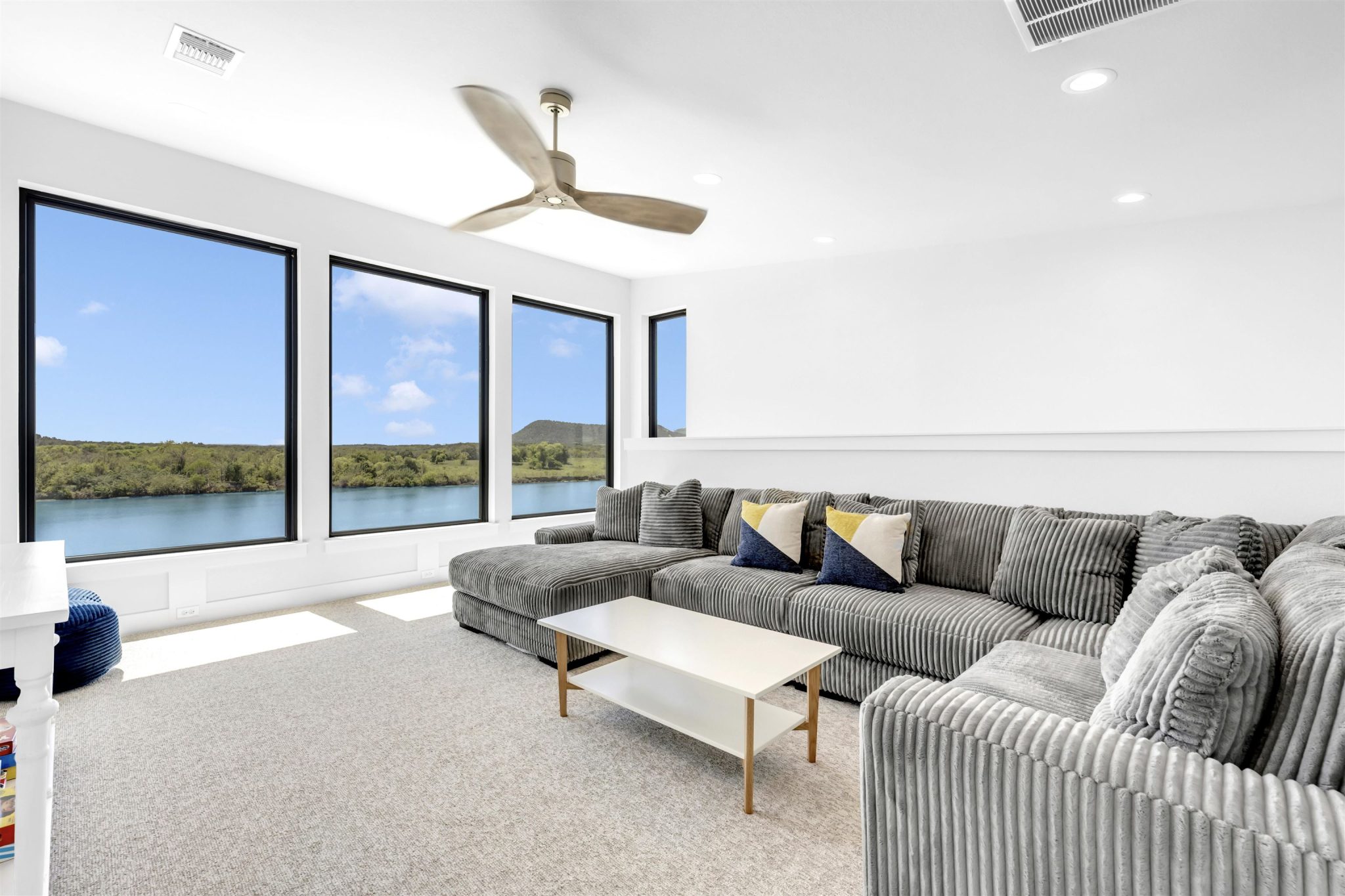 Living room three: Soaring ceilings and massive windows framing peaceful water views.