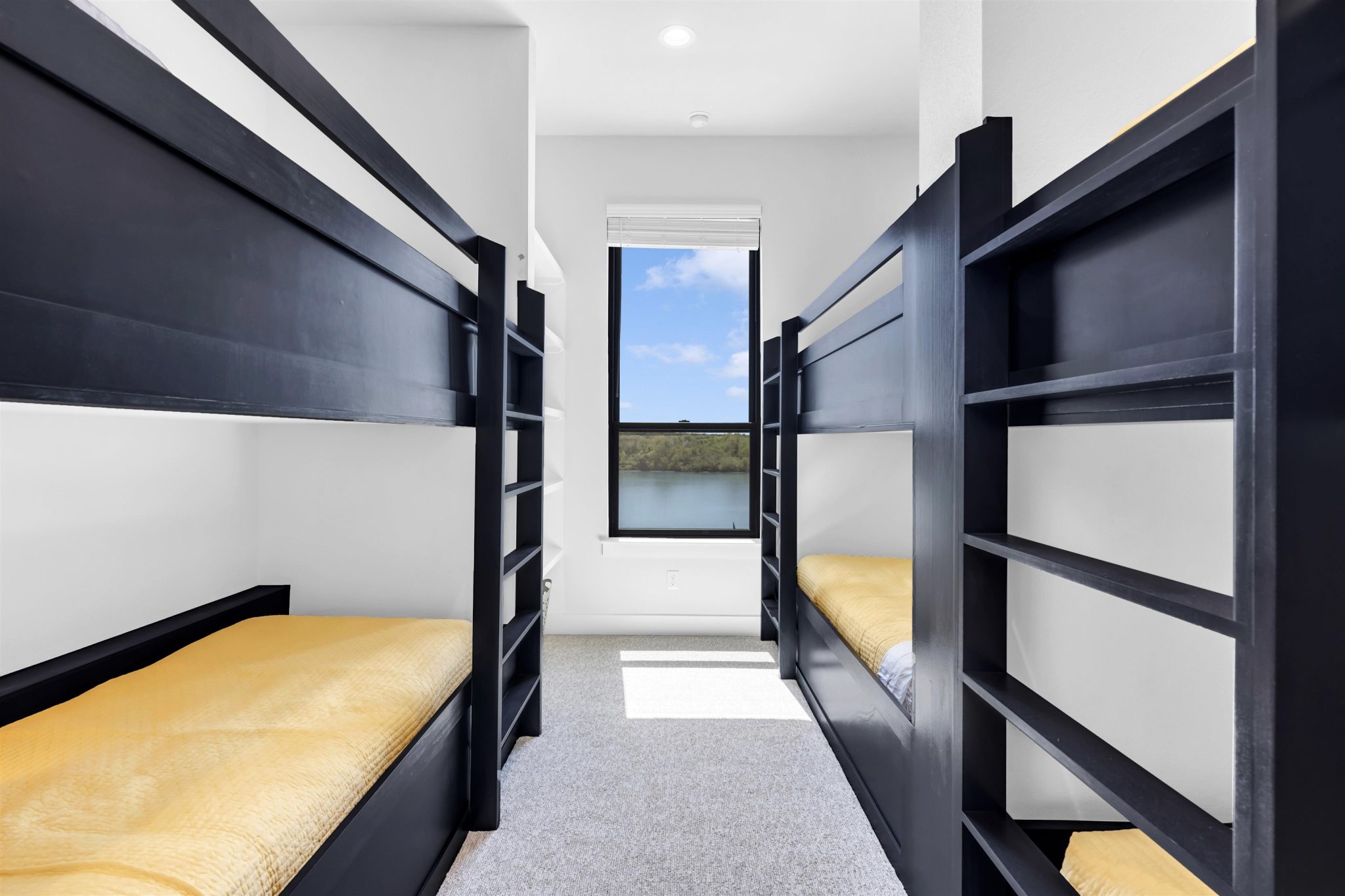 Bedroom seven: Custom built-in bunk beds flank a window frame framing serene water views.
