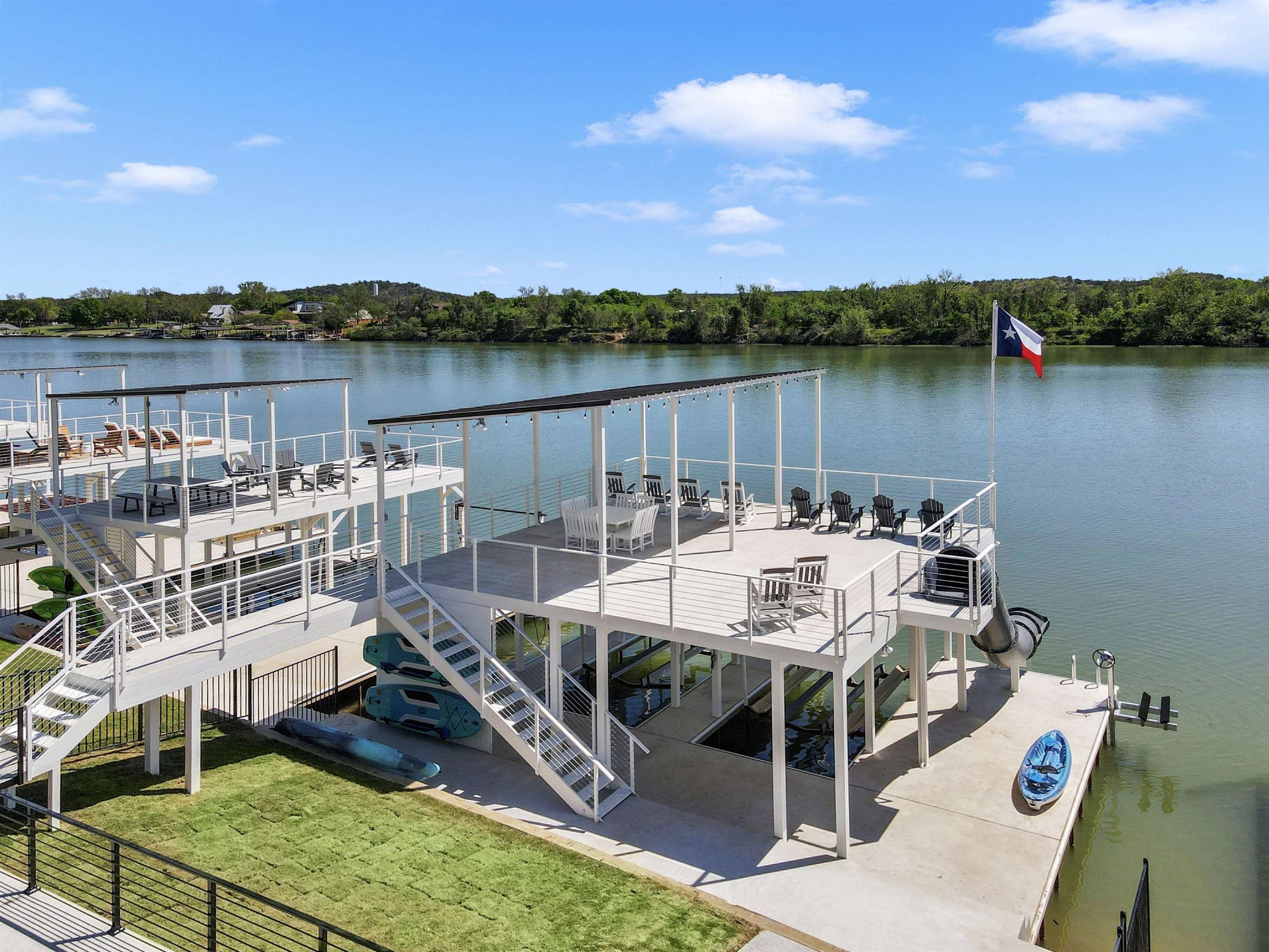 A spacious multi-level dock overlooks the tranquil water under clear blue skies.