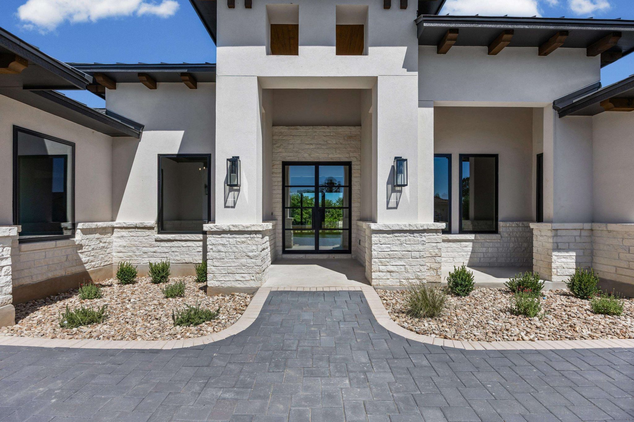 Elegant stone accents complement this home's grand entry, setting a sophisticated tone.