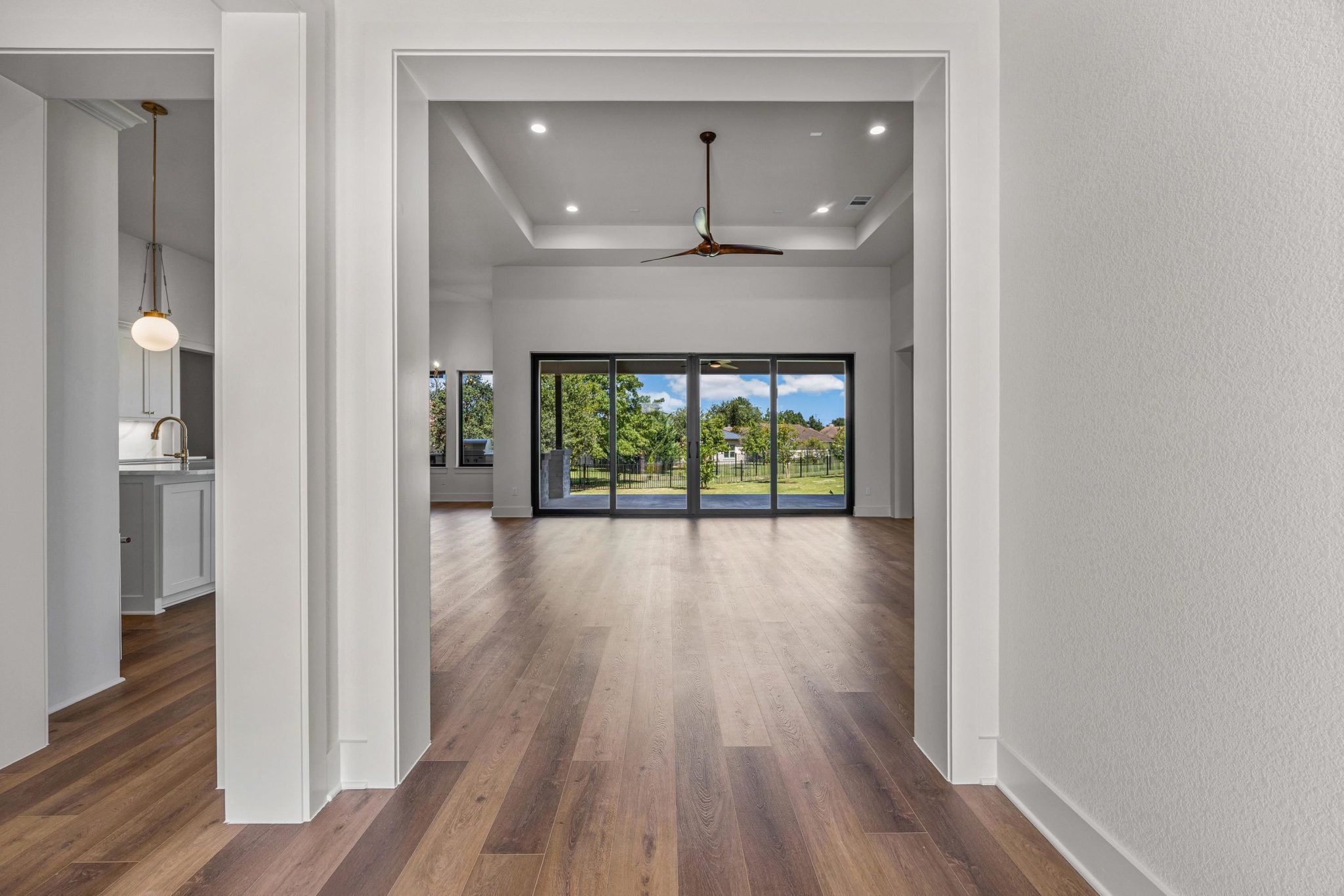 Hardwood flooring extends throughout the floor plan, leading to large sliding doors