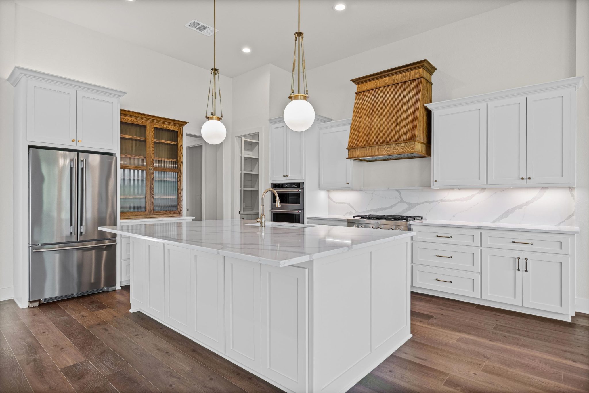A well-lit kitchen with a spacious island and sleek stainless steel appliances