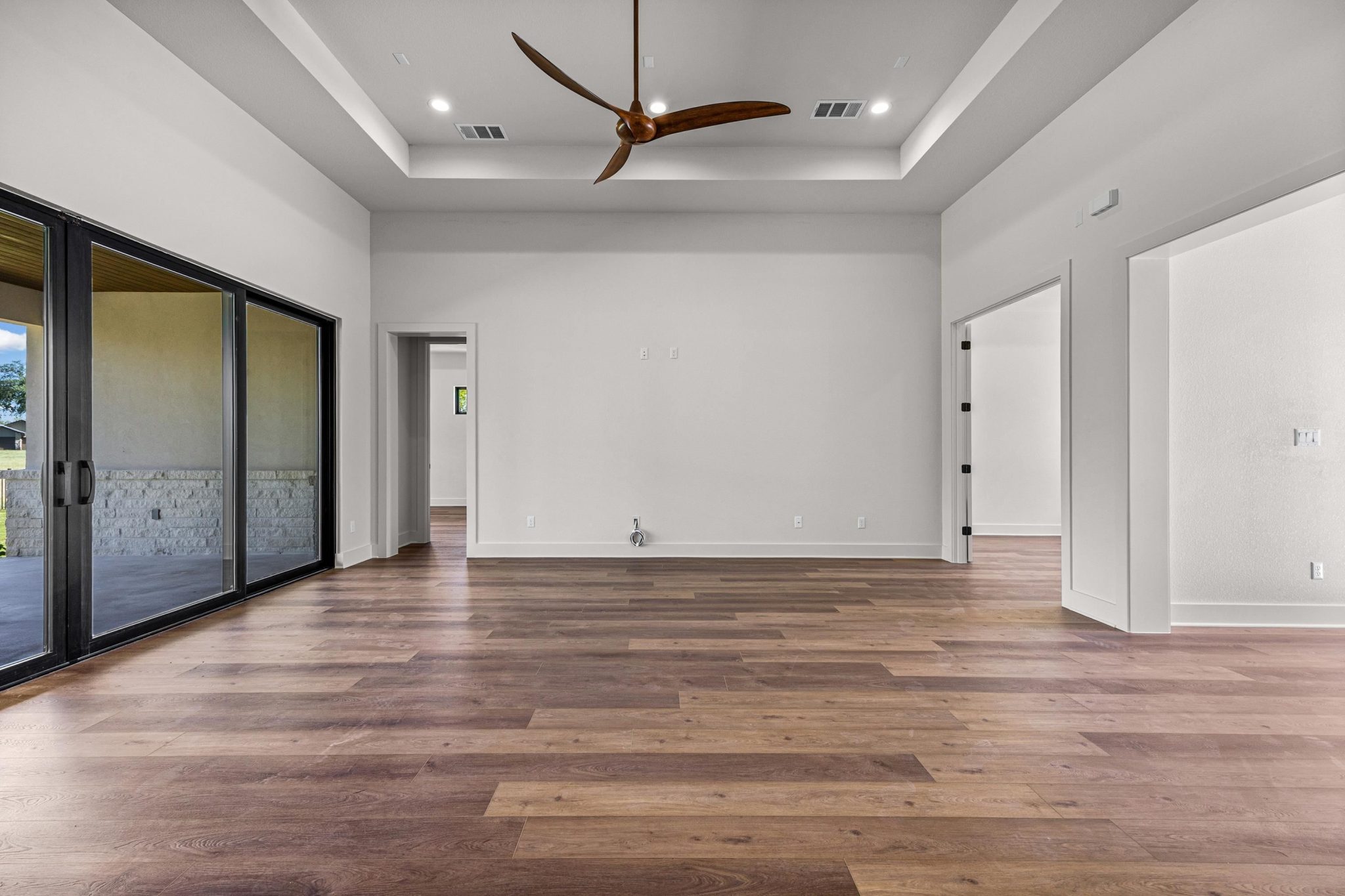 Warm hardwood flooring extends to open-concept room,recessed lighting, and sleek ceiling upgrade fan