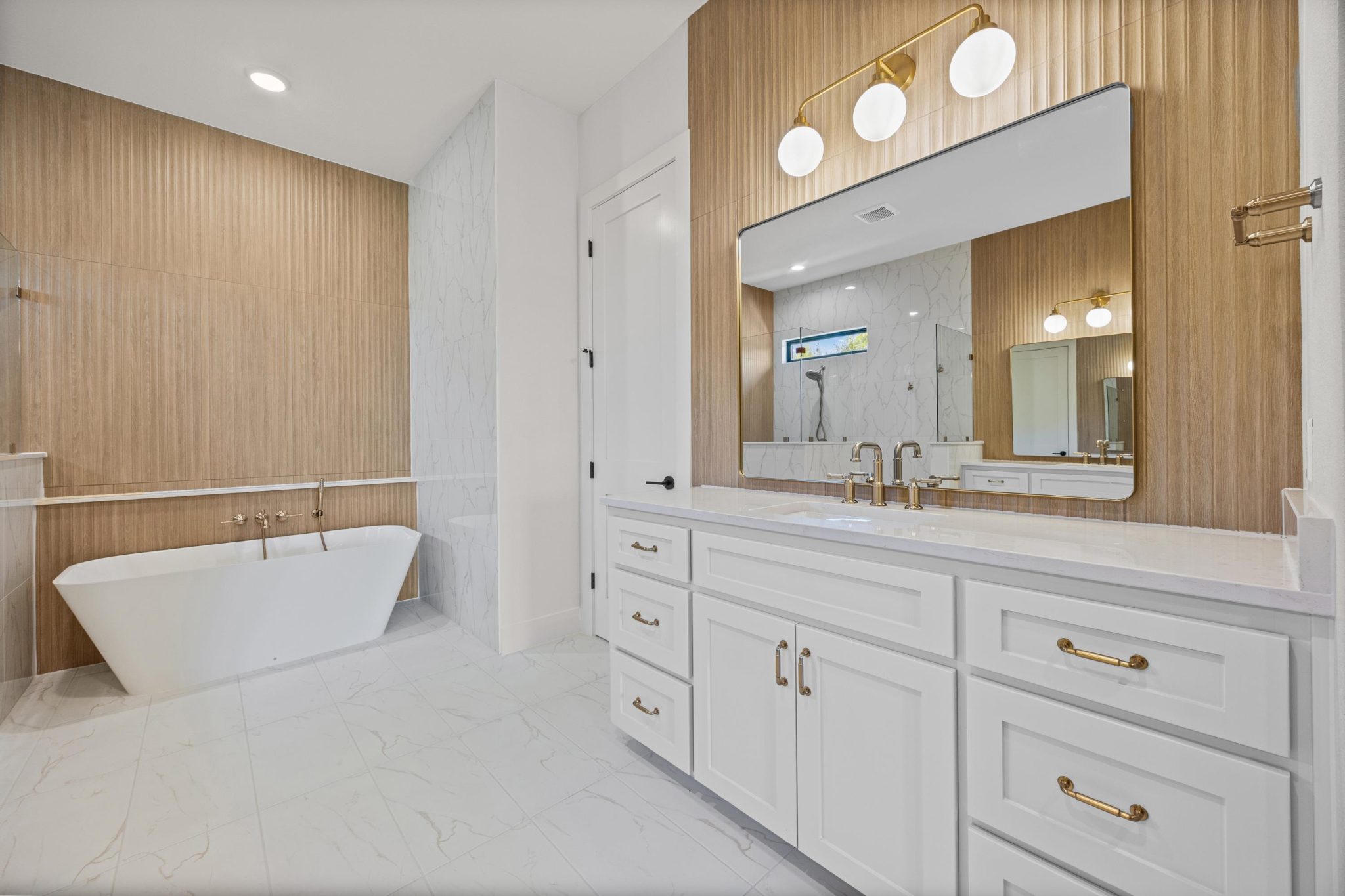 Well-appointed primary bathroom showcases a freestanding tub and beautiful wall design.