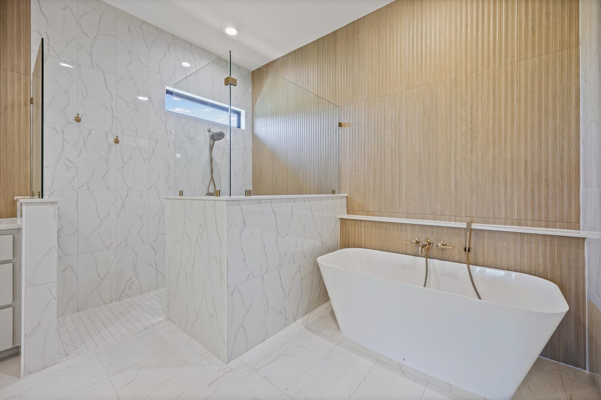 Indulge in a spa-like retreat w/ serene bath featuring a freestanding tub & glass-enclosed shower