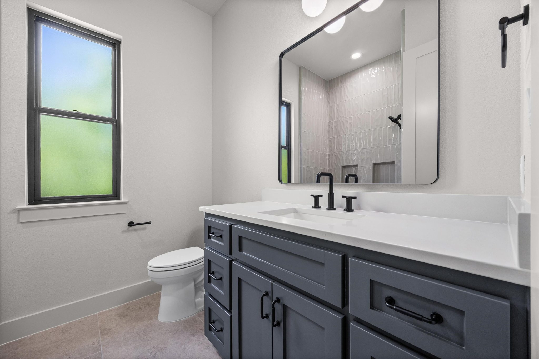 Well-lit secondary bath with upgraded cabinetry and fixtures