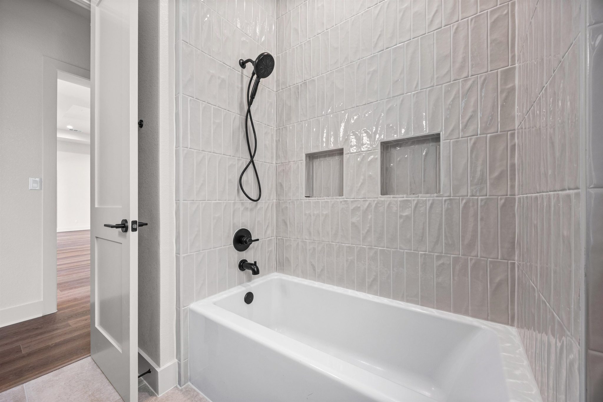 Soaking tub with modern black fixtures offers a relaxing retreat.