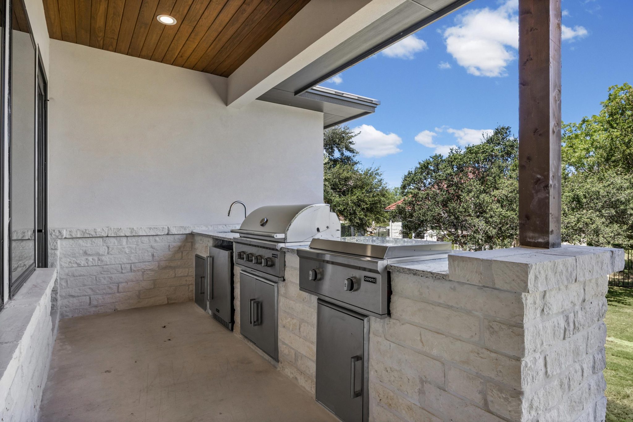 Outdoor kitchen with upgraded Coyote stainless steel appliances creates an ideal setting