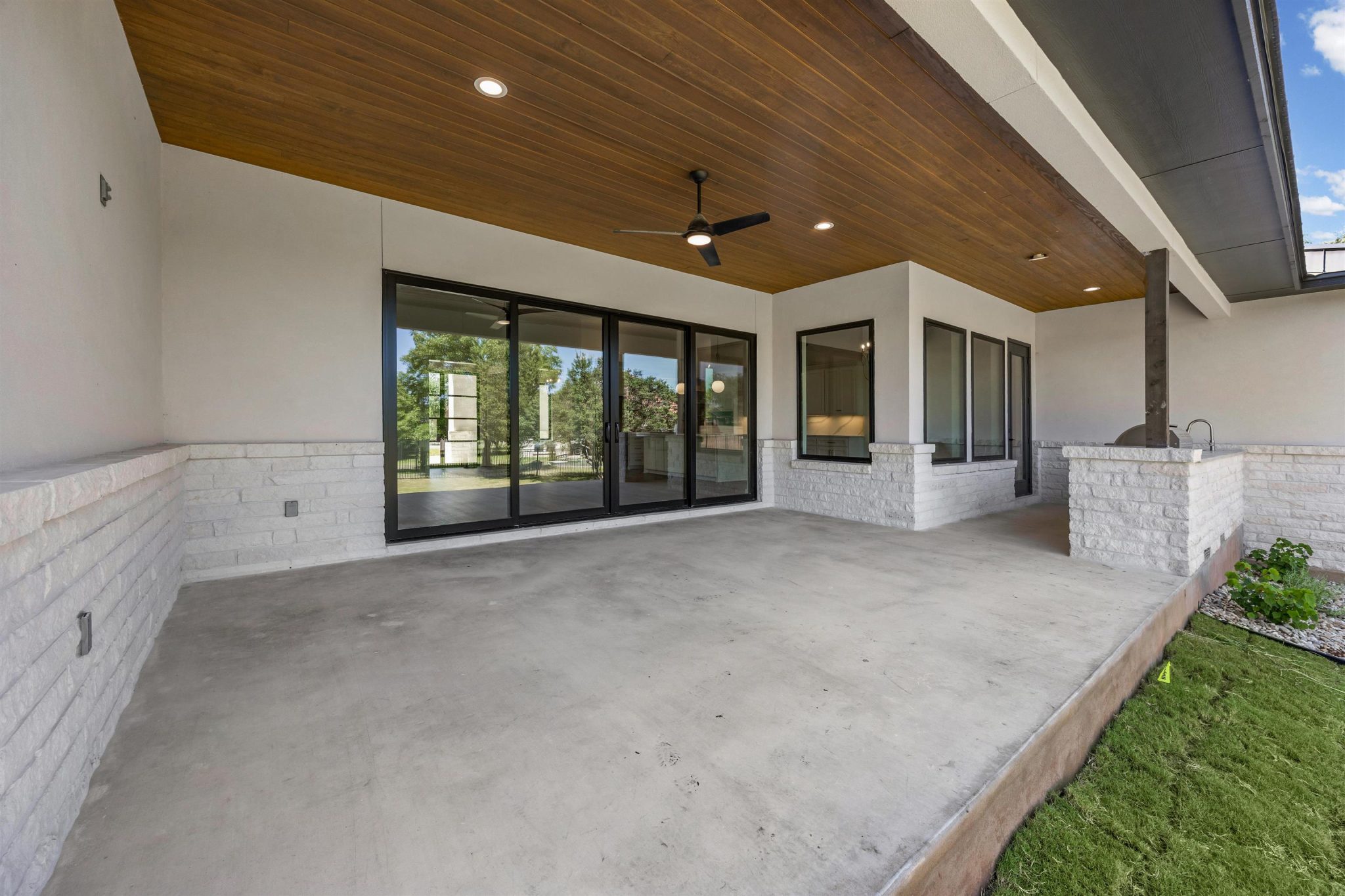 Inviting outdoor living space, covered patio w/ wooden ceiling next to the outdoor kitchen