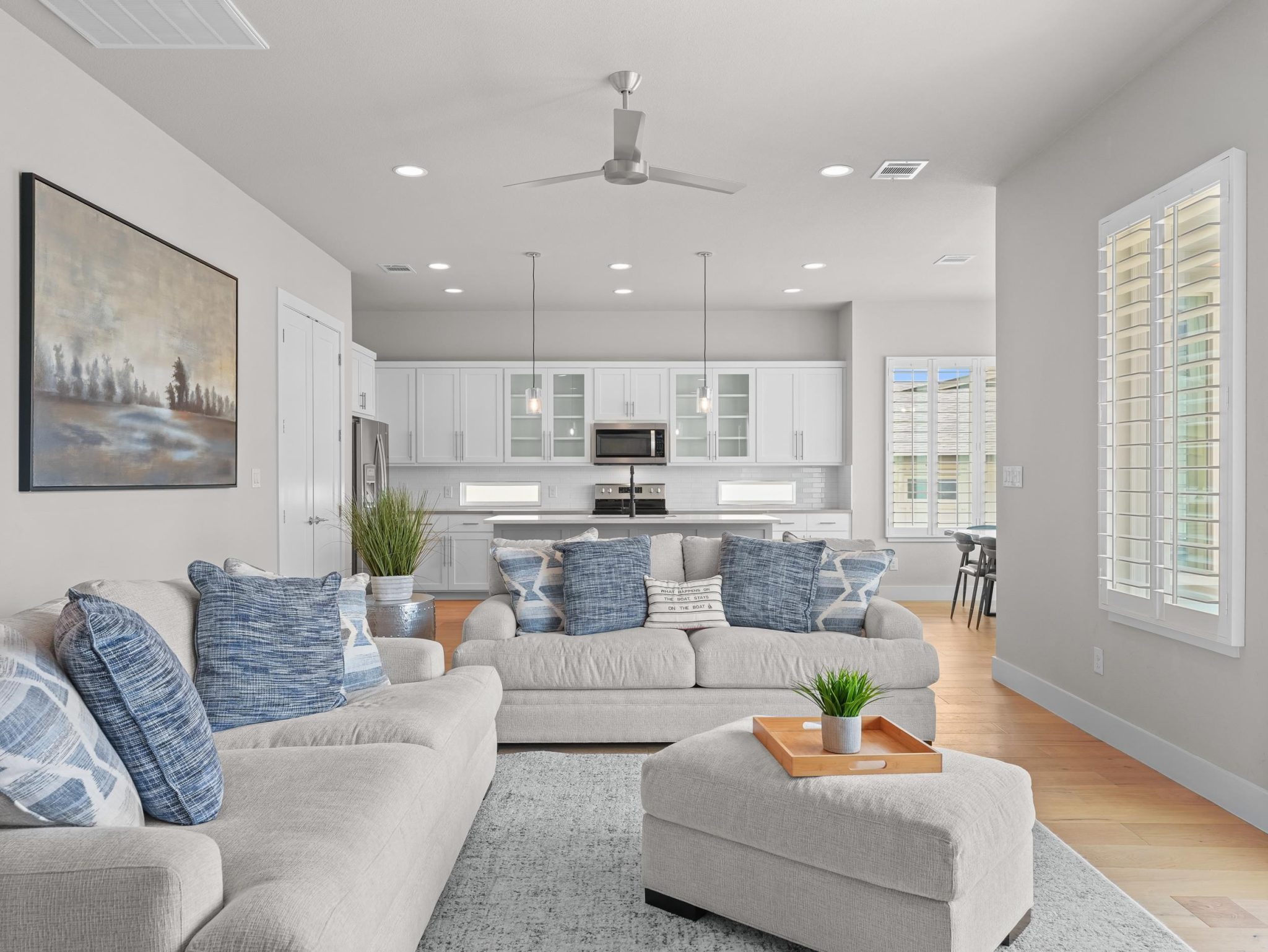 An open floor plan seamlessly connects the living space to a modern kitchen.