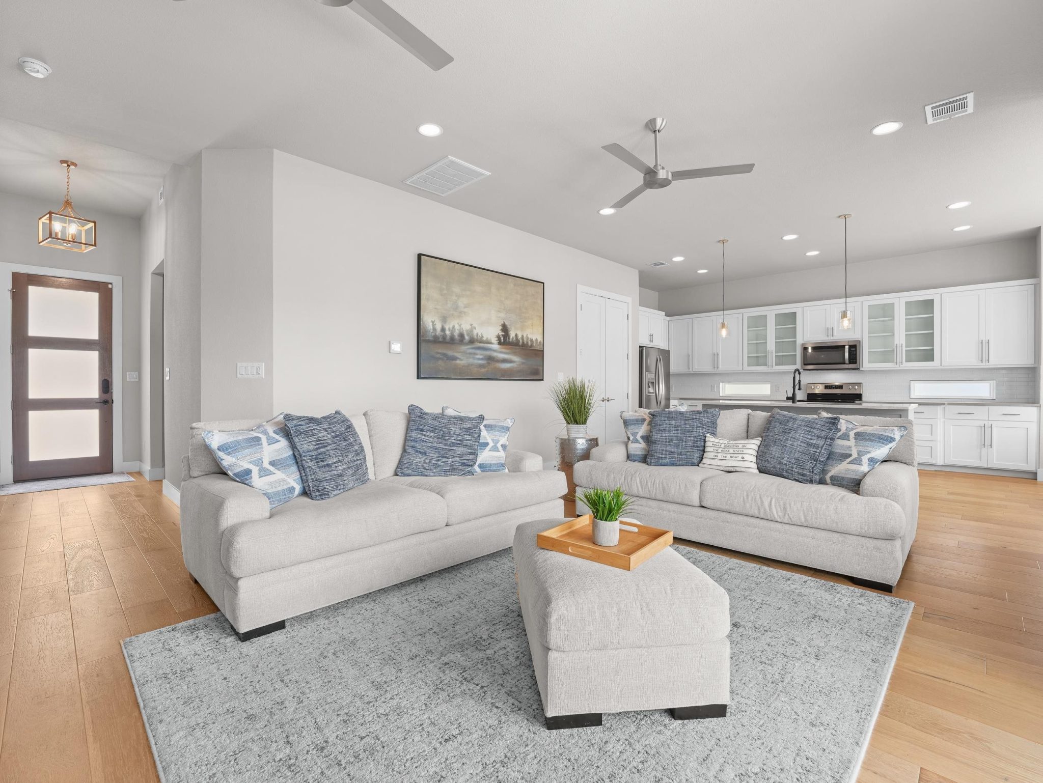 Smooth wood floors flow seamlessly through this open-concept living area and modern kitchen.