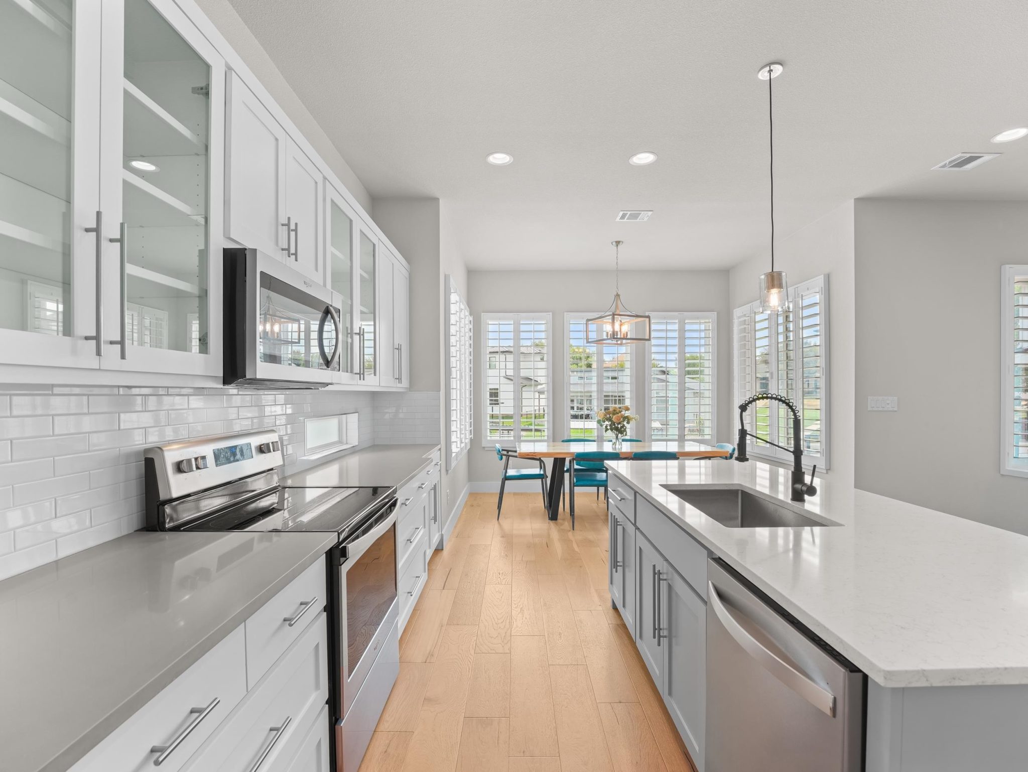 Gleaming stone countertops and classic wood flooring anchors this bright, open culinary space.