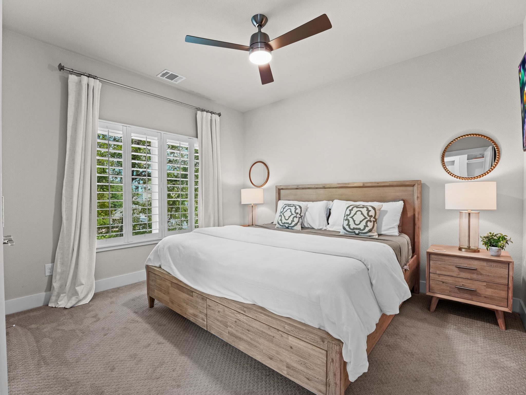 Plush carpeting and plantation shutters create a tranquil, comfortable atmosphere in this restful BR
