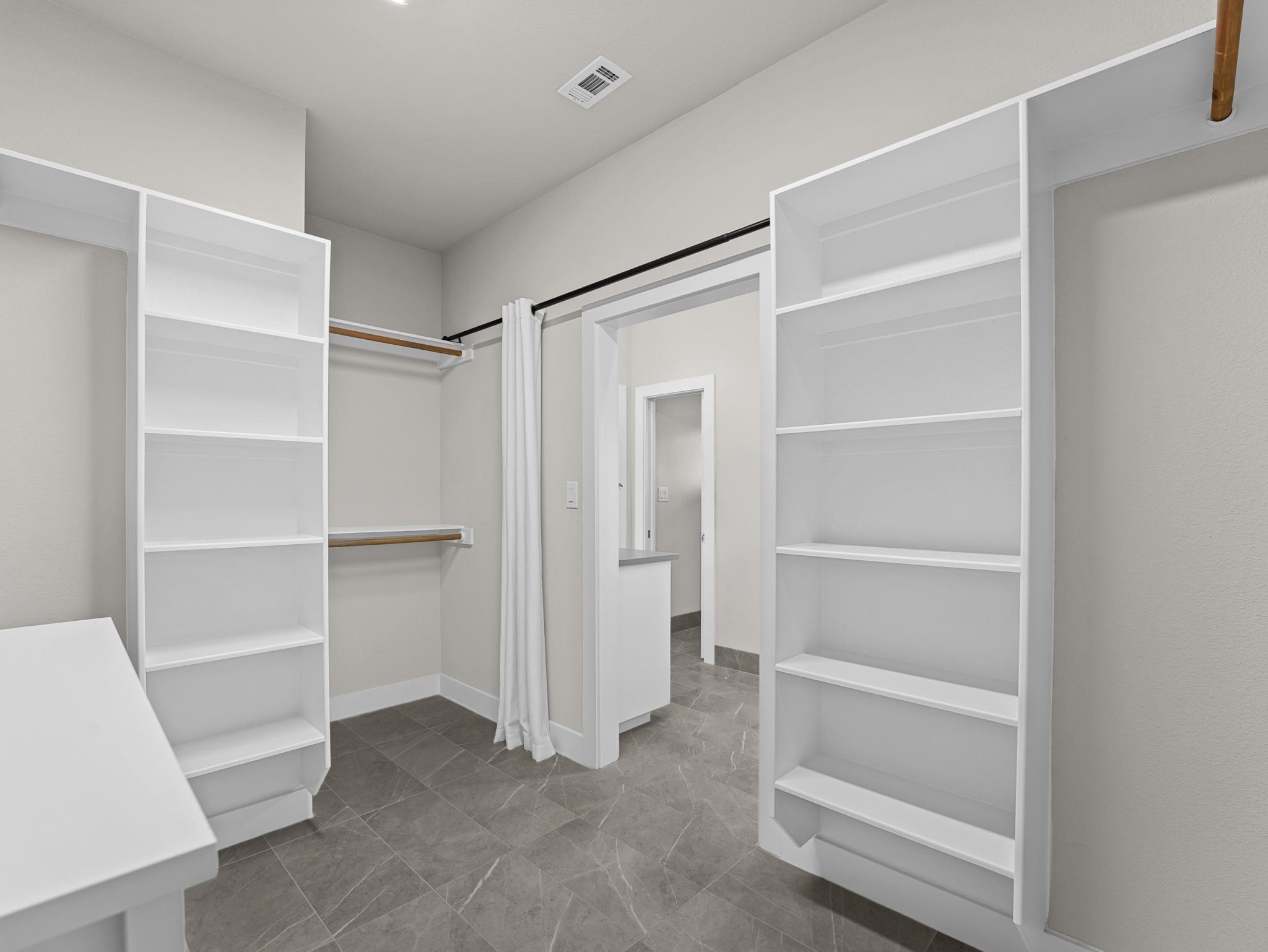 Generous storage meets elegant tile flooring in this meticulously organized closet space.