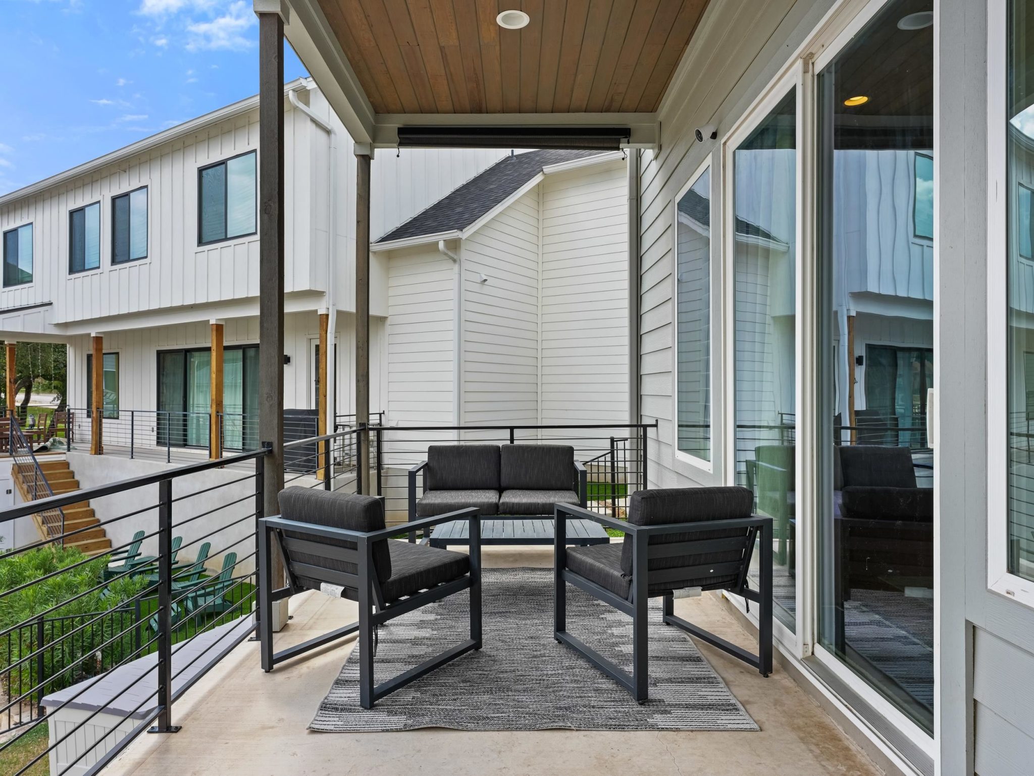 Sliding glass doors open onto a covered back porch with a wood-plank ceiling.