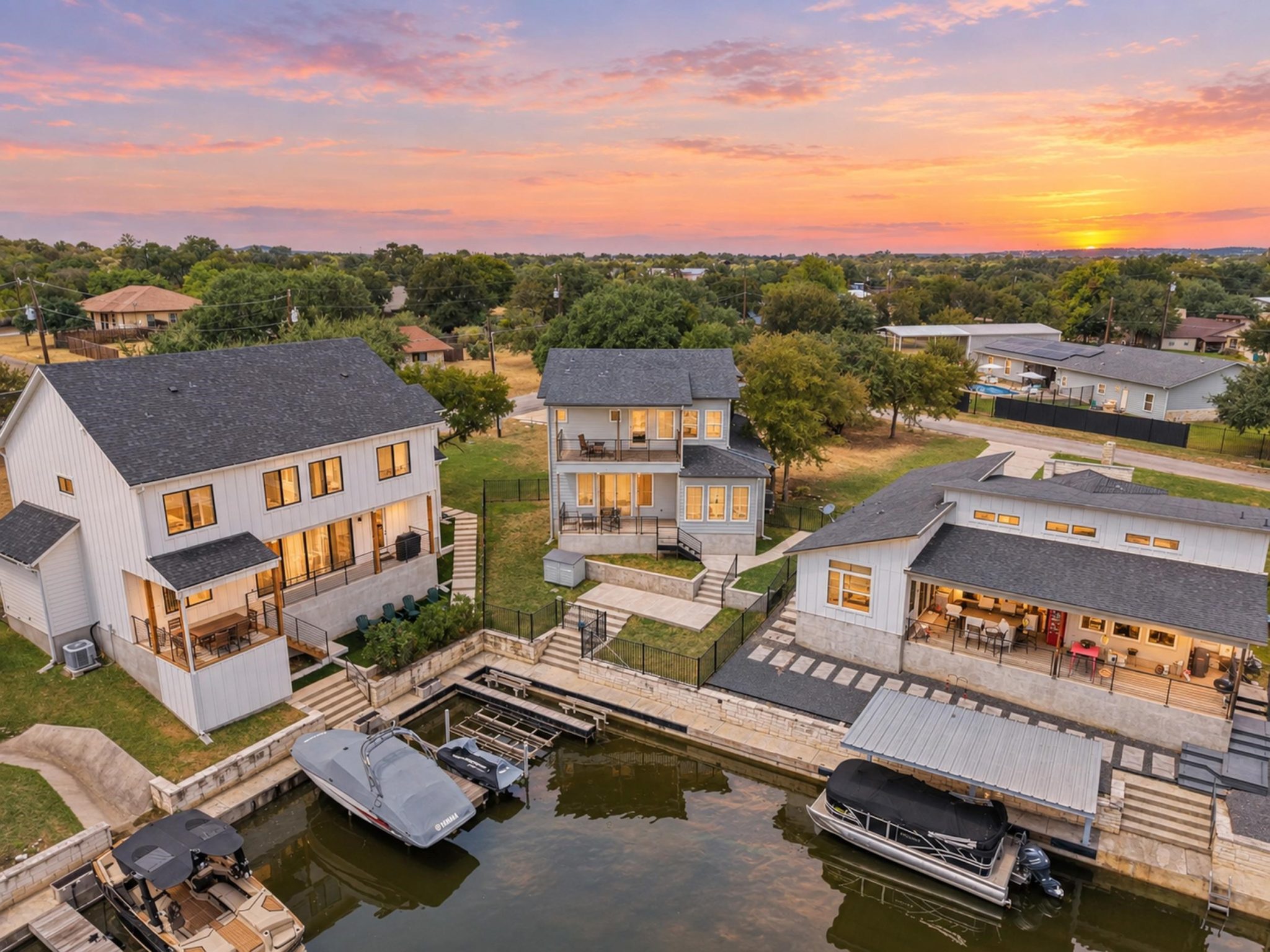 Multi-level waterfront properties feature private boat docks along the calm shoreline.
