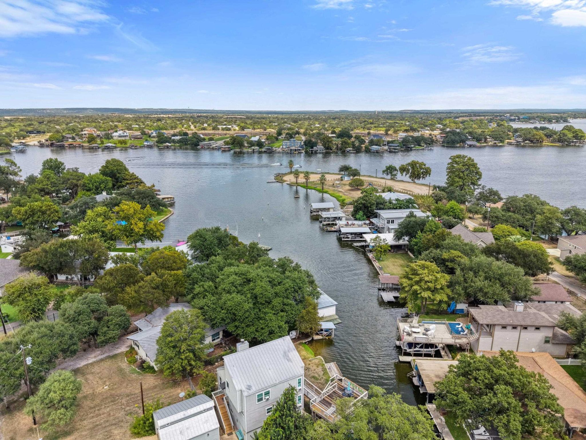 An aerial perspective showcases a peaceful waterfront neighborhood tucked along the winding riverban